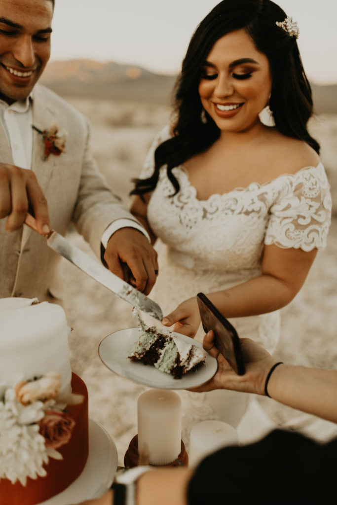 groom putting slice of cake on brides plate