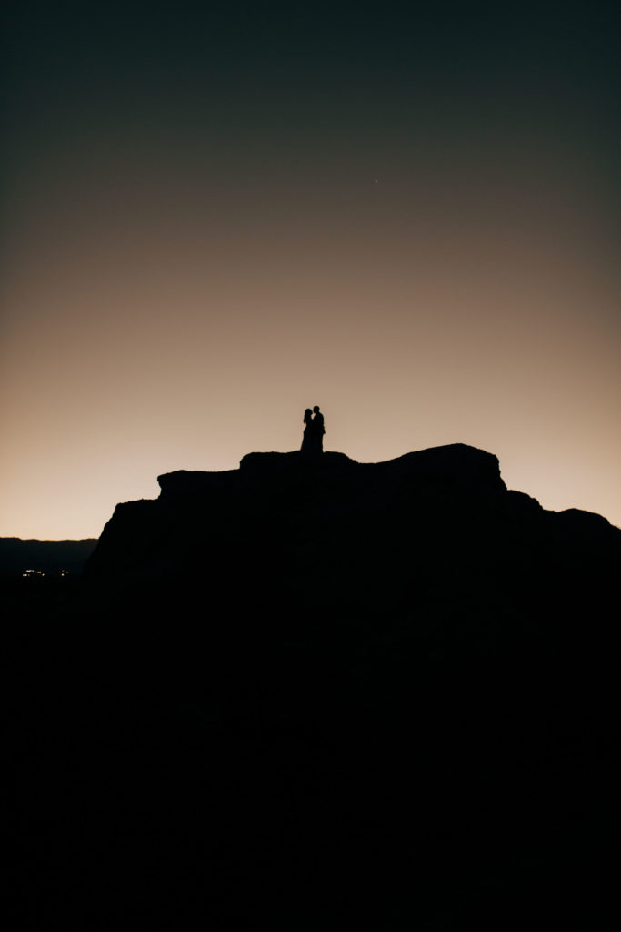 silhouette of bride and groom on rocks 