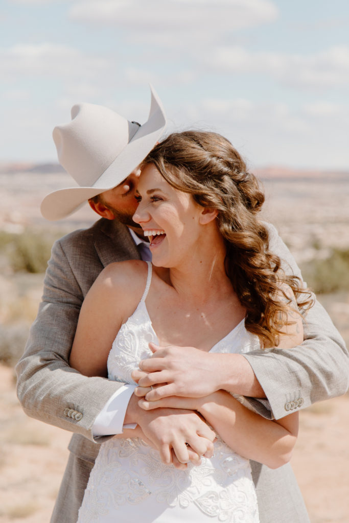 Groom with Cowboy hat Kissing Bride on the Cheek  