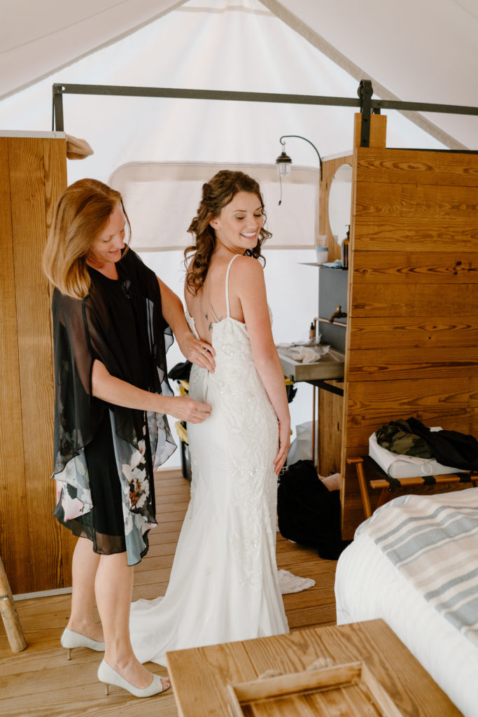 Mother helping bride in dress 