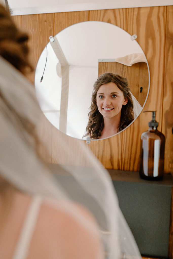 Bride looking in mirror before ceremony 