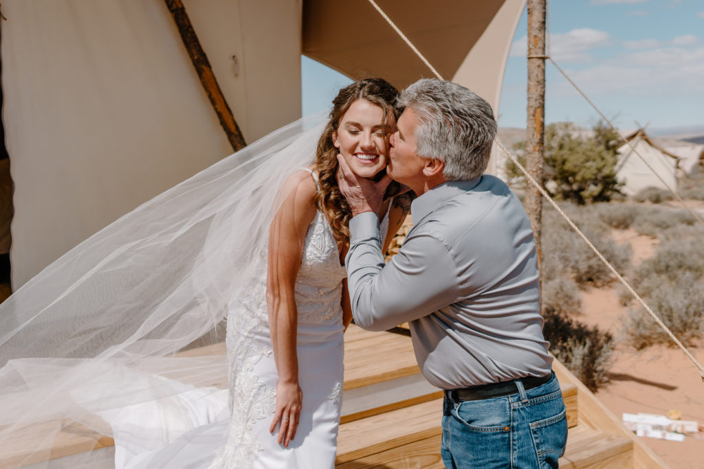 Father kissing bride on cheek after father-daughter first look 