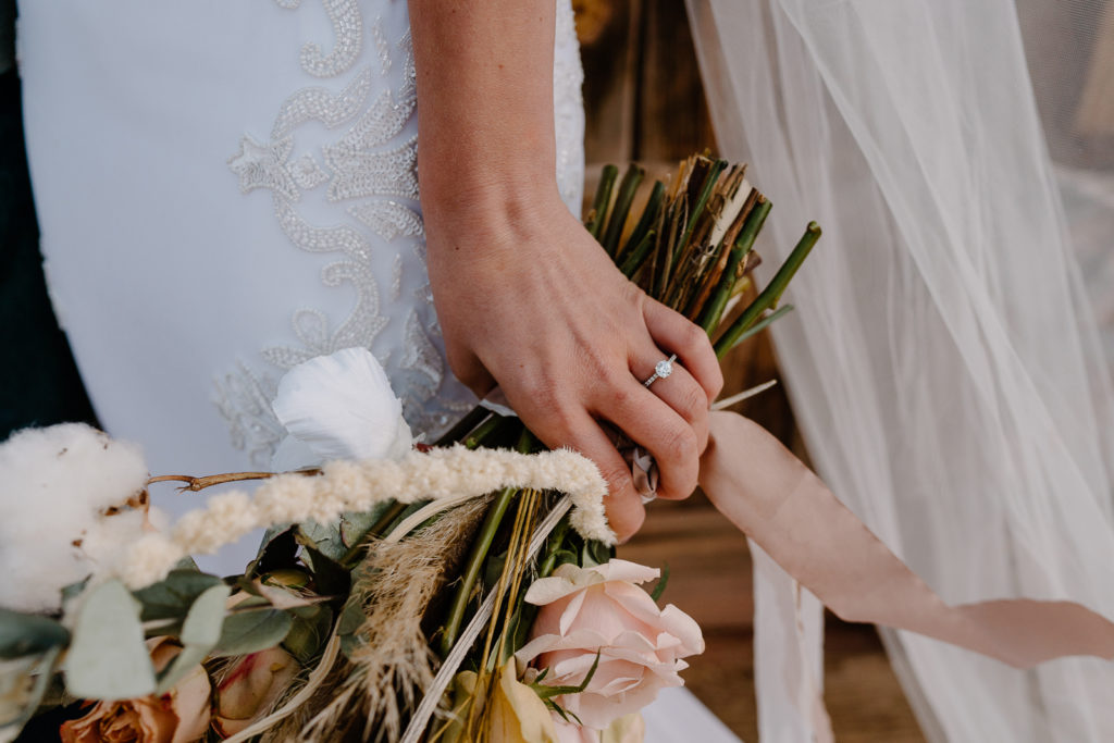Bride holding bouquet with wedding ring 
