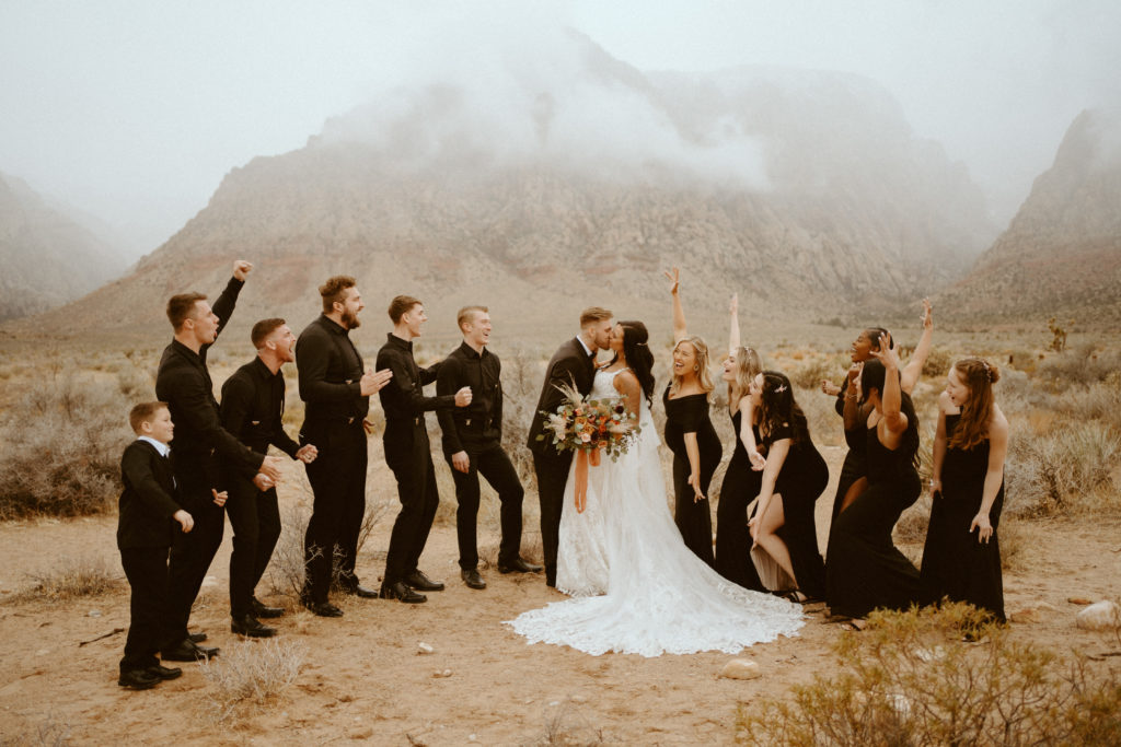 Wedding party wearing all black celebrating while the Bride and Groom kiss for Red Rock Bridals & Simple Affair Micro-Wedding 