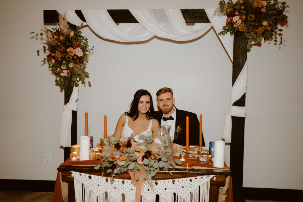 Newlyweds sitting at their sweetheart table during the reception 