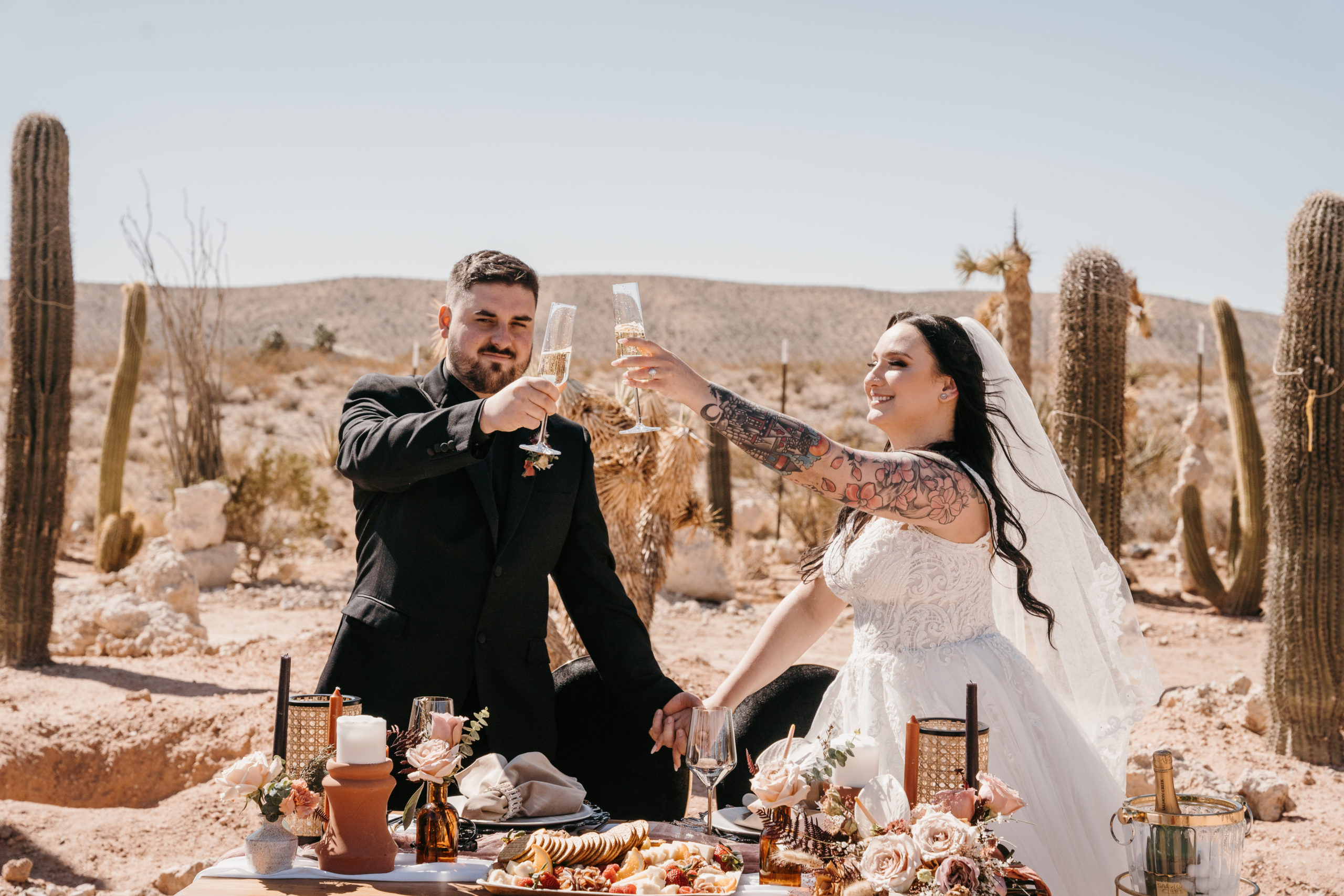 Newlyweds doing a toast at designed sweetheart table after Modern-Boho Las Vegas Elopement