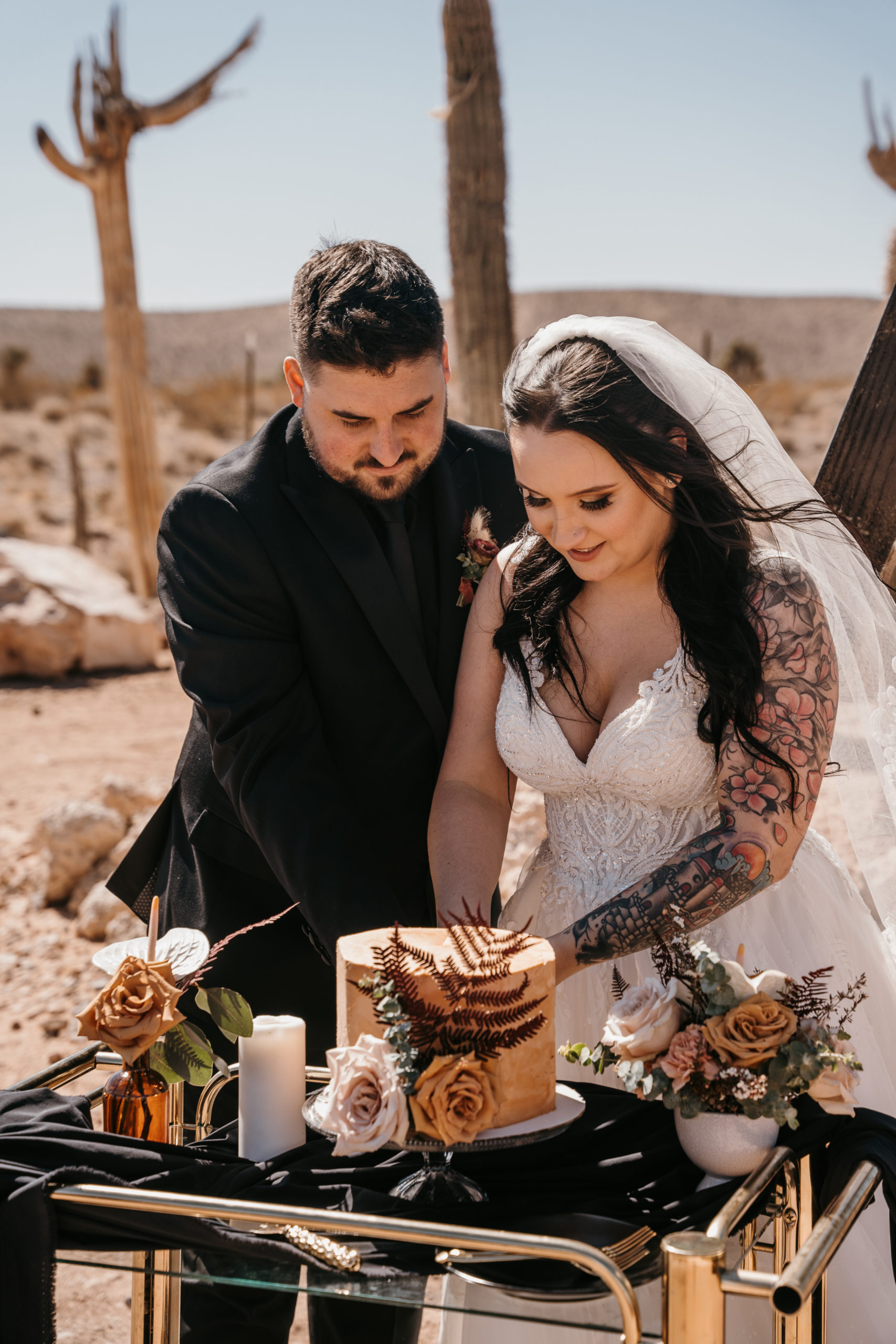 Newlyweds cutting elopement cake for their Modern-Boho Las Vegas Elopement