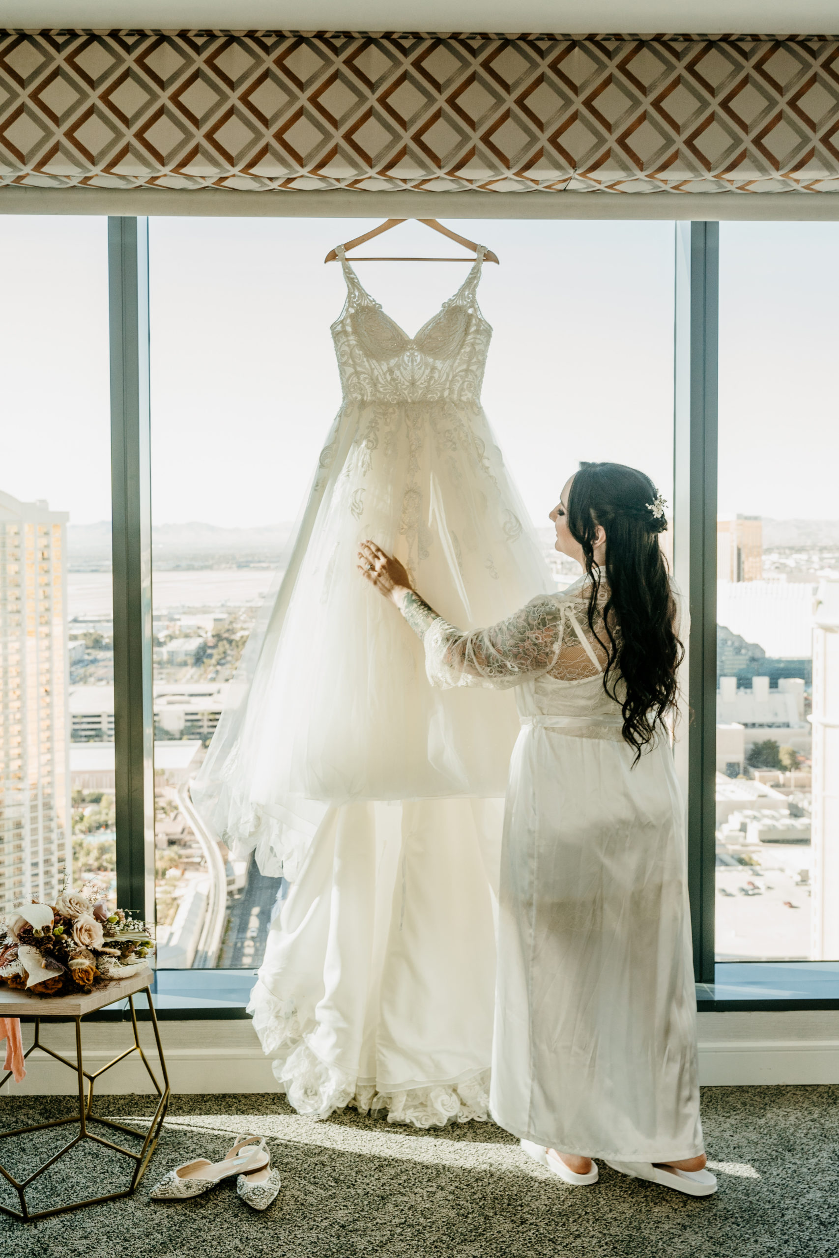 Bride admiring and looking at wedding dress before getting in it 
