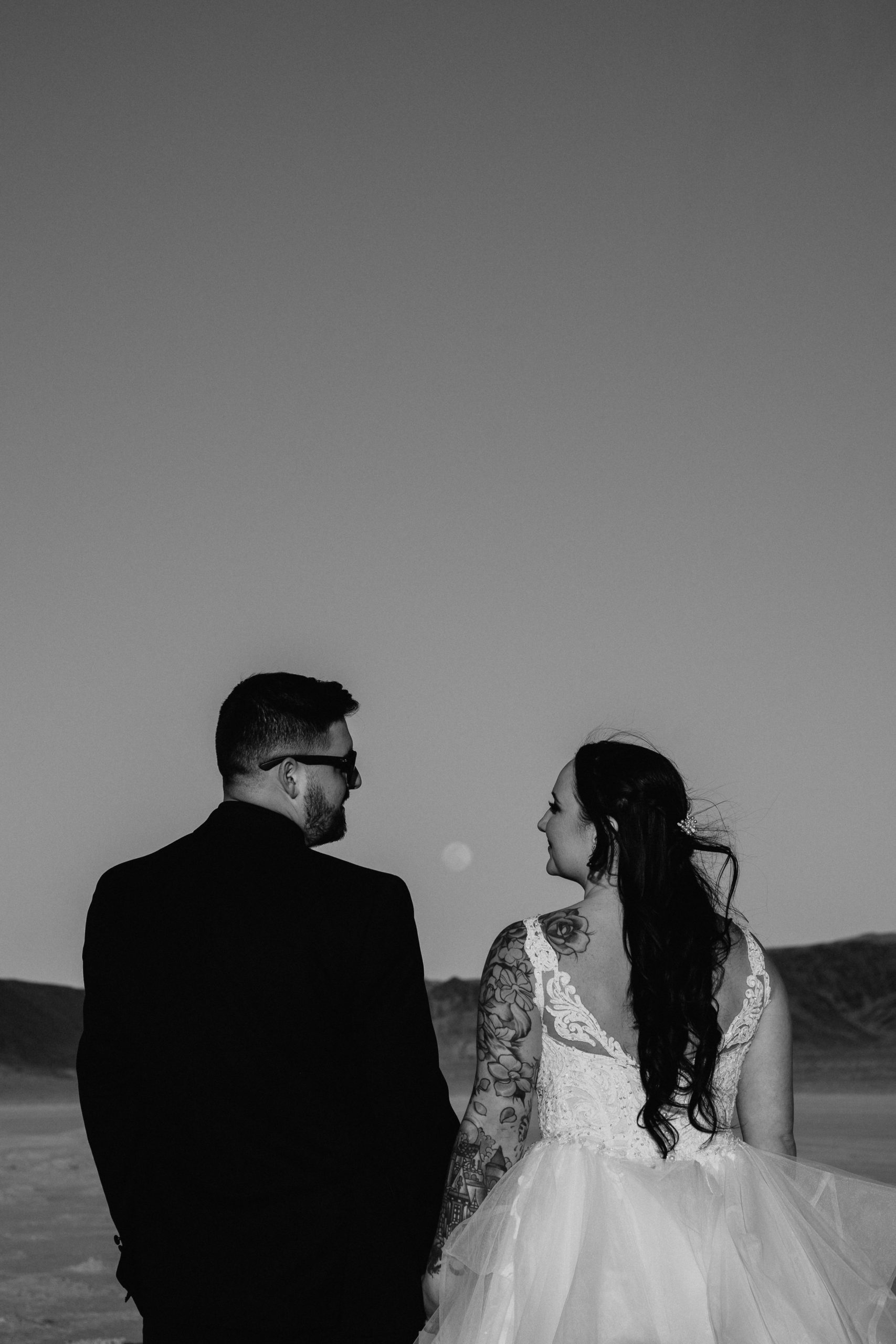 Couple walking away with moon between them after Modern-Boho Las Vegas Elopement