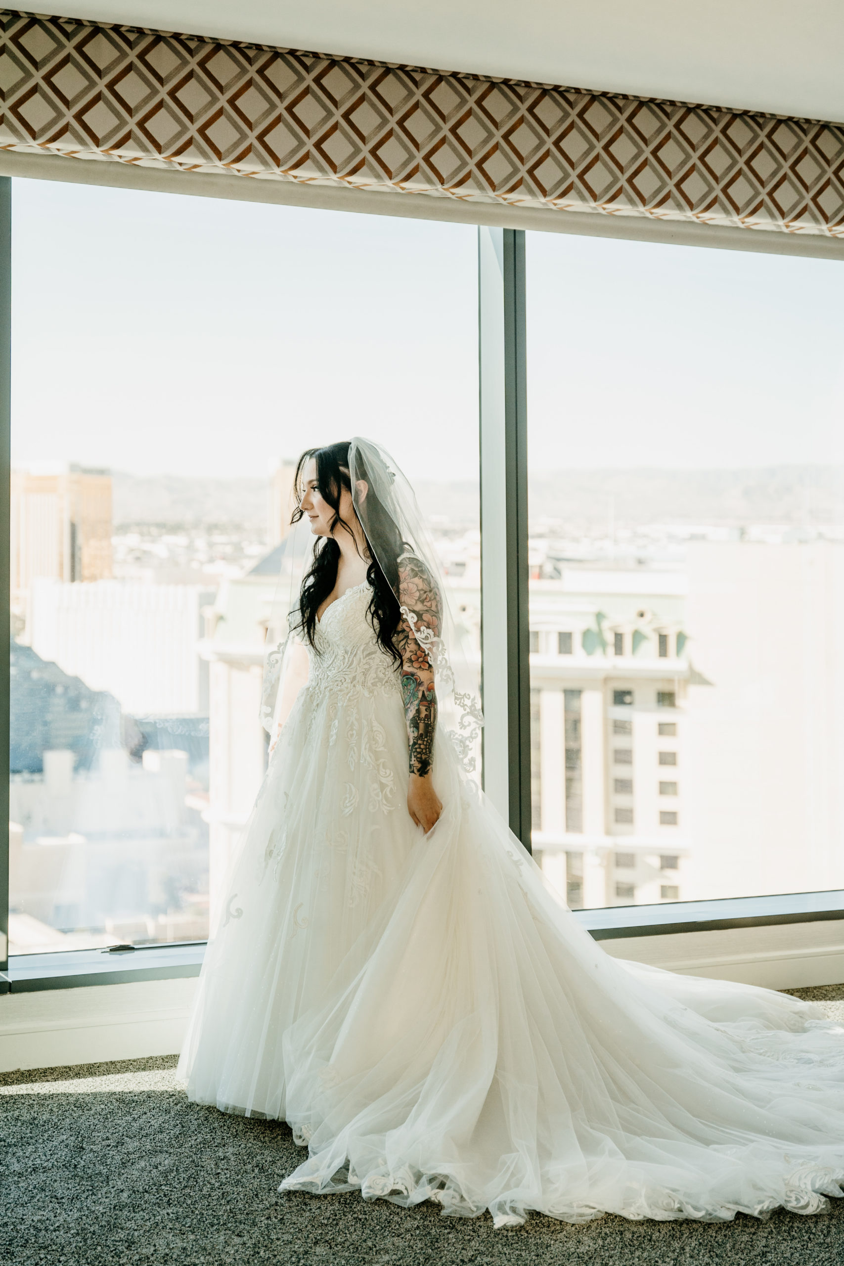 Bride looking at window after getting in wedding dress 