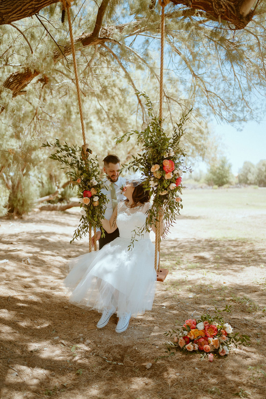Bride and groom on tree sing decorated in floral 