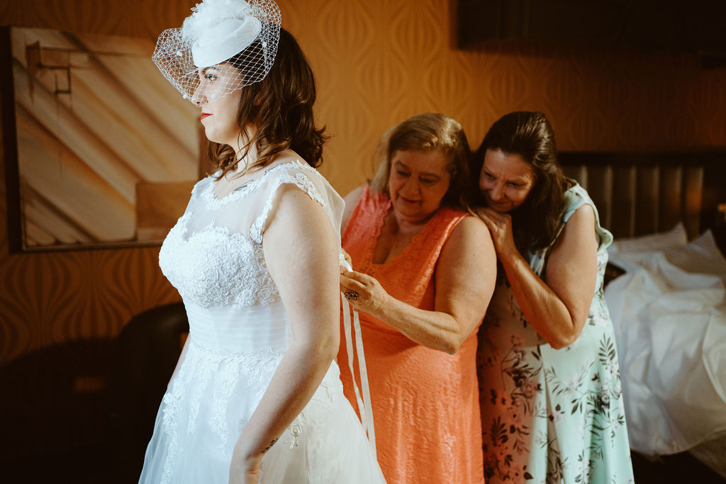 Mother of the Bride and Mother of the Groom tying brides dress for Las Vegas Wedding 