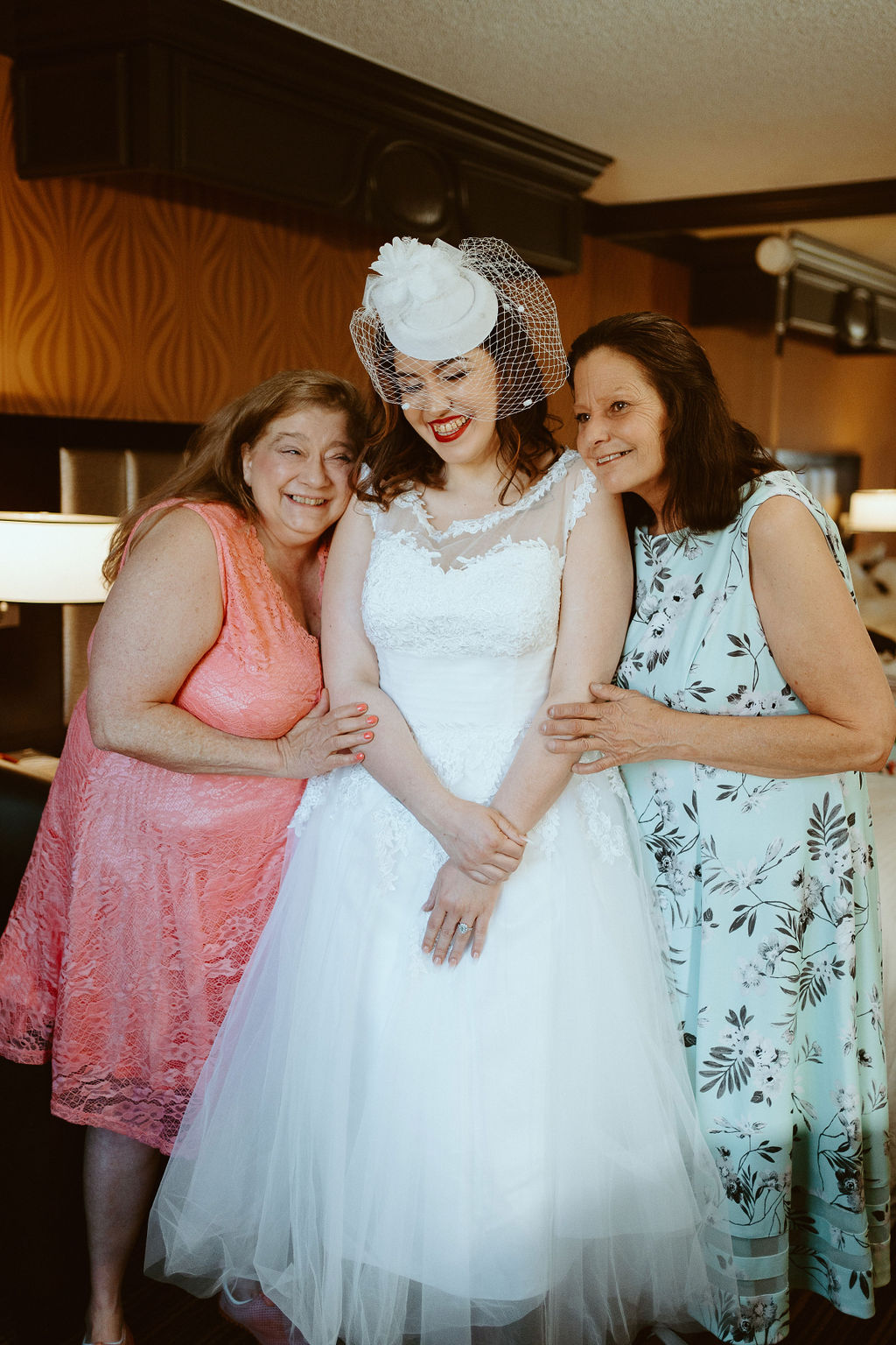 Mother of Groom, Bride, and Mother of the Bride smiling after bride finished getting ready 
