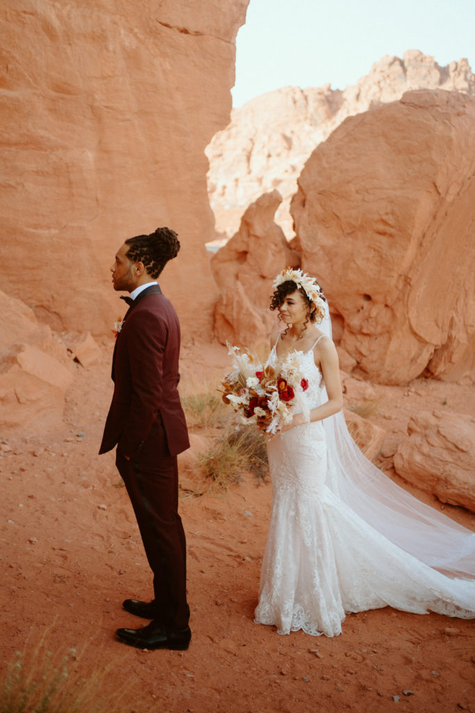 Bride standing behind Groom's back for First Look in Valley of Fire 
