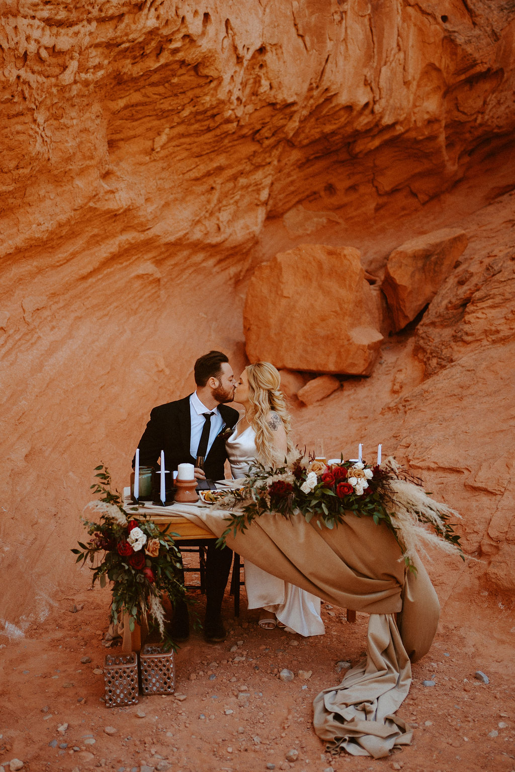 Couple kissing at Moody Bohemian Sweetheart Table with Charcuterie as a snack 