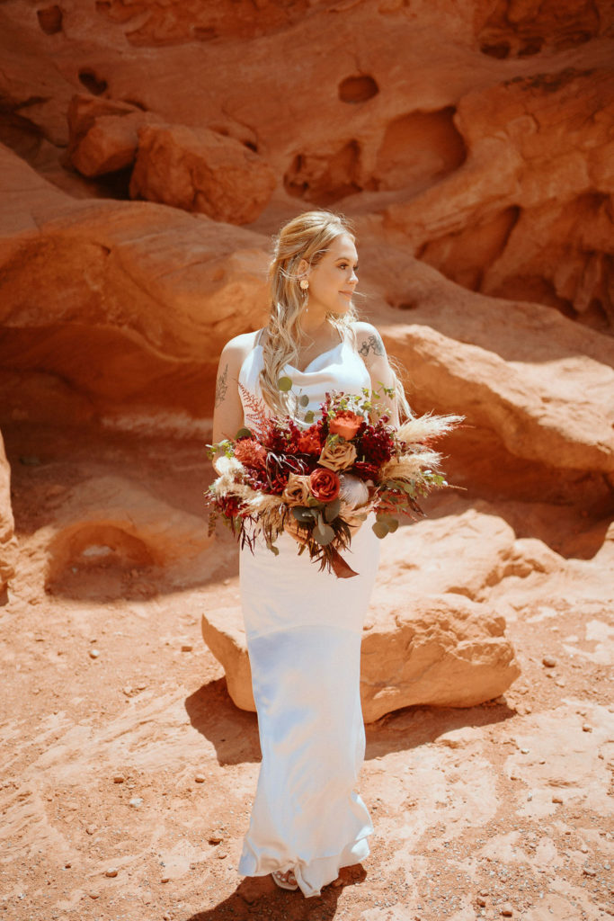 Bride standing and looking away with moody bouquet 