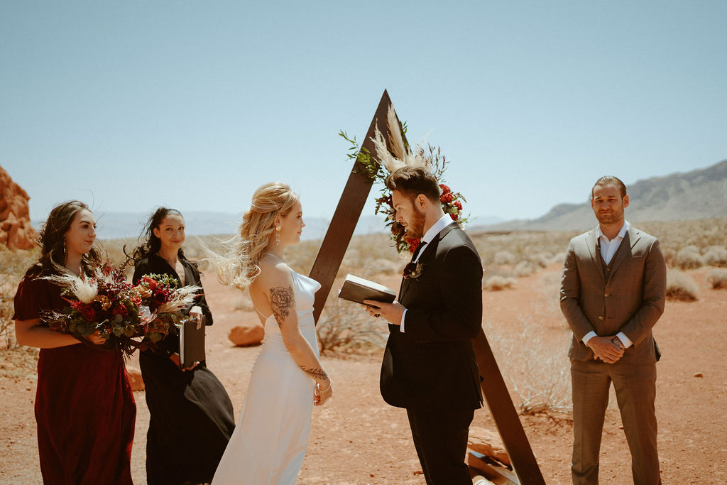 groom reading personal vows to bride  in moody bohemian desert elopement  