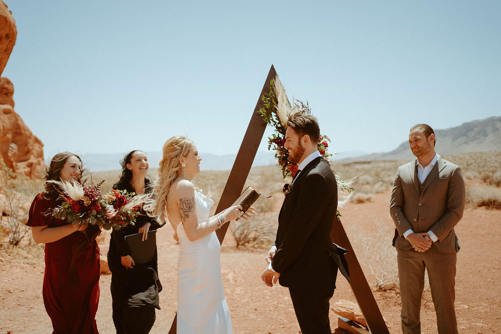 bride reading her personal vows to groom in moody bohemian desert elopement 