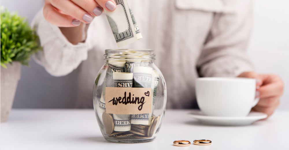 money being put into a jar labeled "wedding"