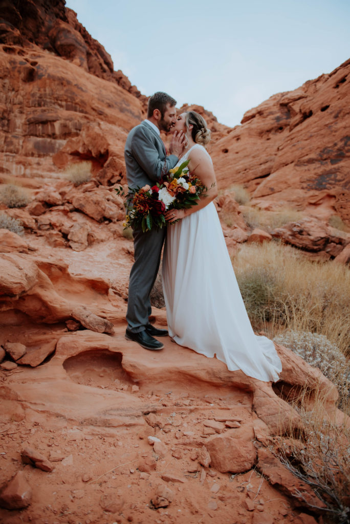 Bride and Groom kissing in scenic red rocks during the fall 