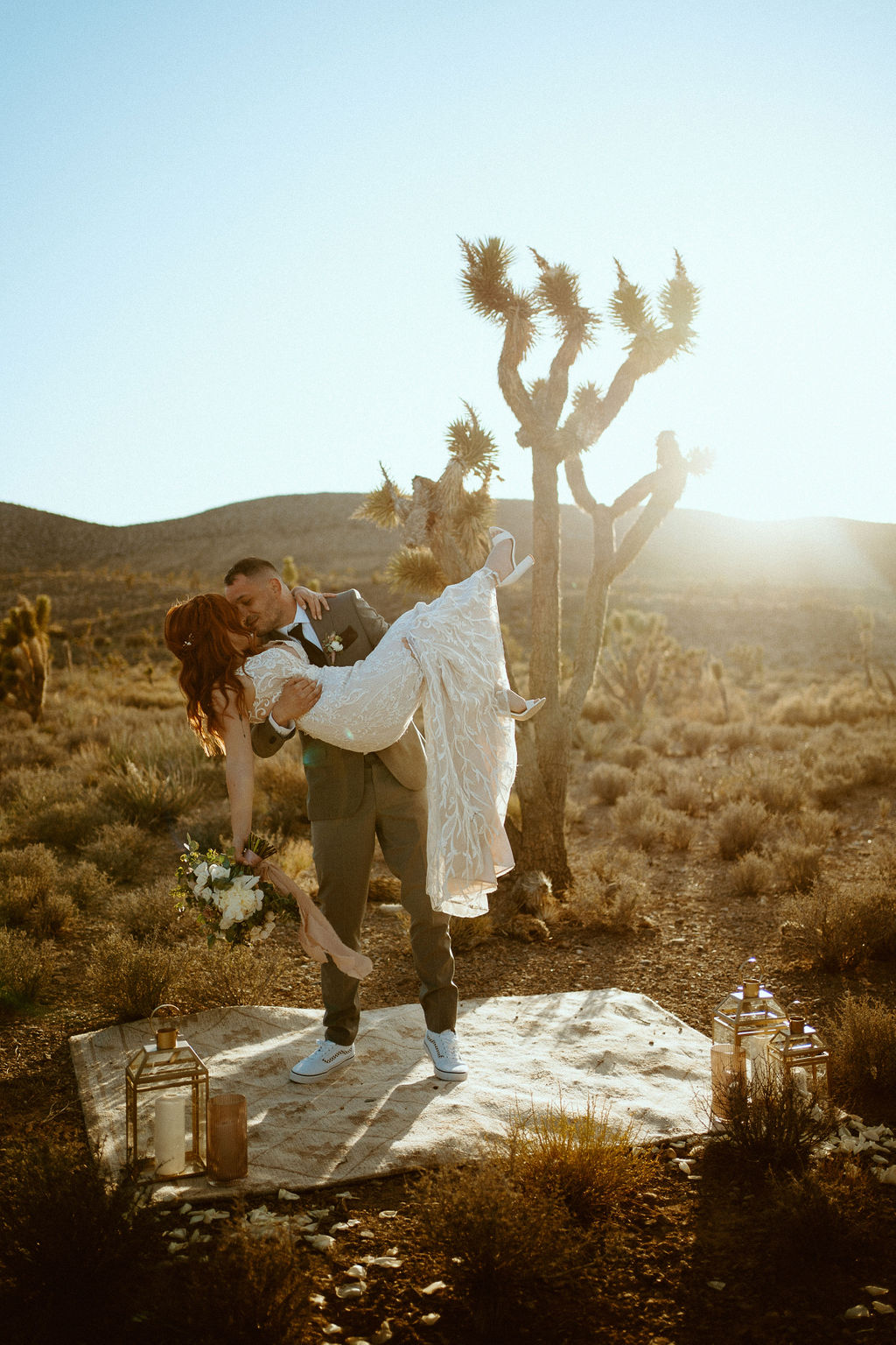 Husband holding wife at ceremony location during Sunset during their Kyle Canyon Timeless Desert Elopement