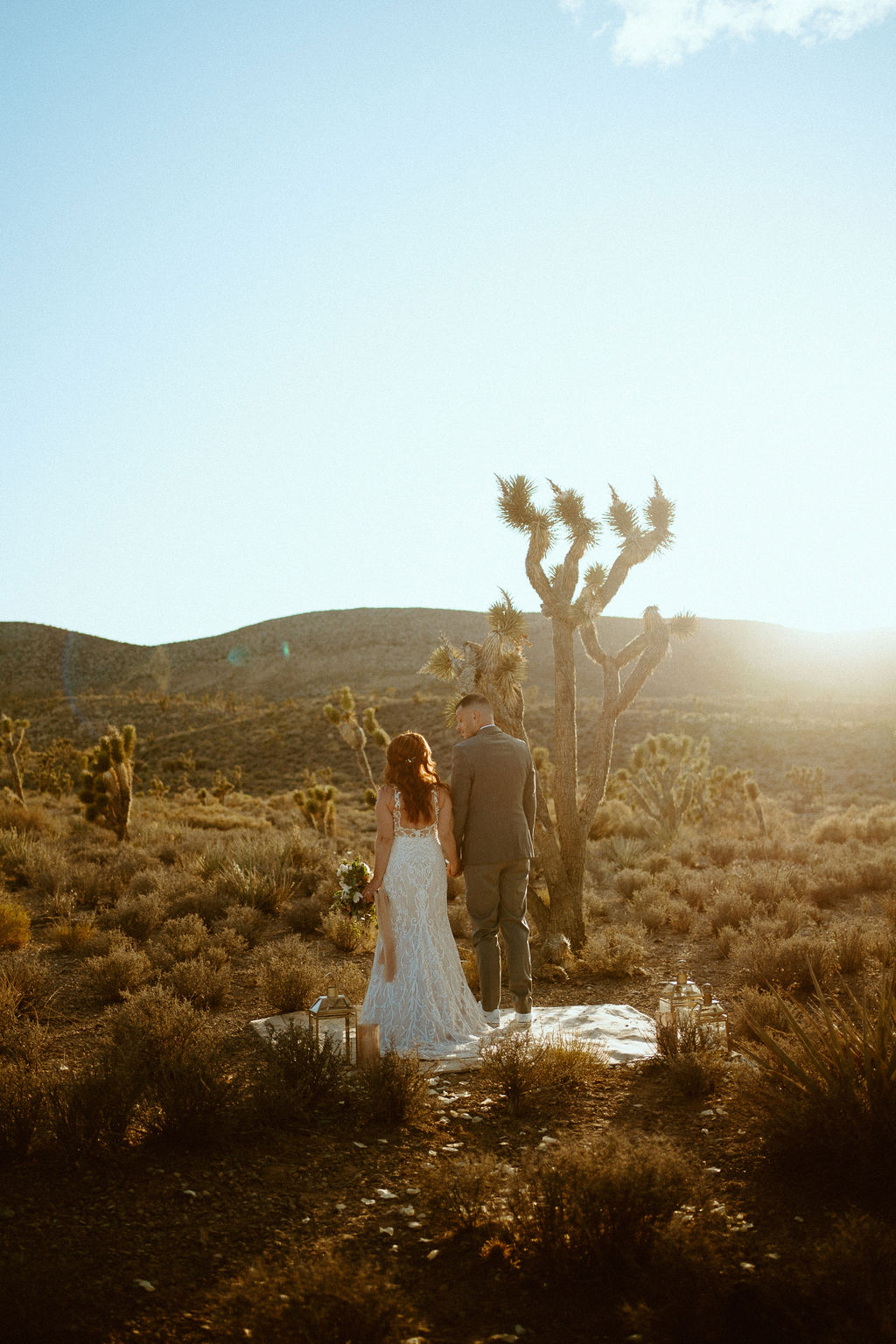 couple standing in desert during sunset