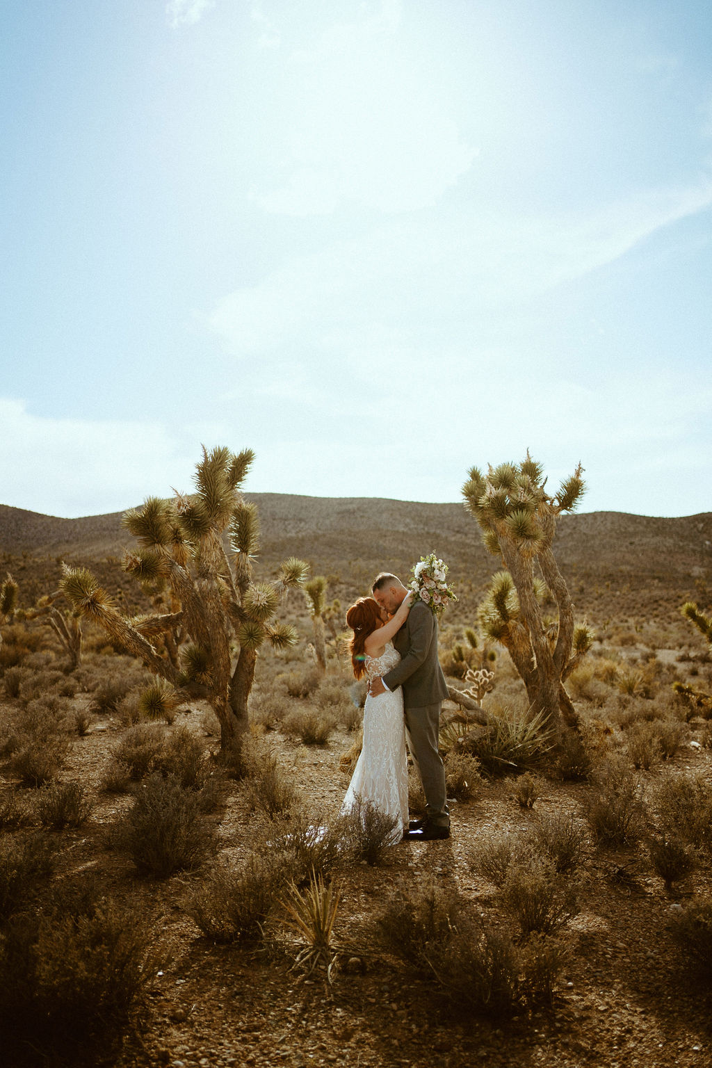 Kissing between two Joshua Trees at Kyle Canyon Timeless Desert Elopement