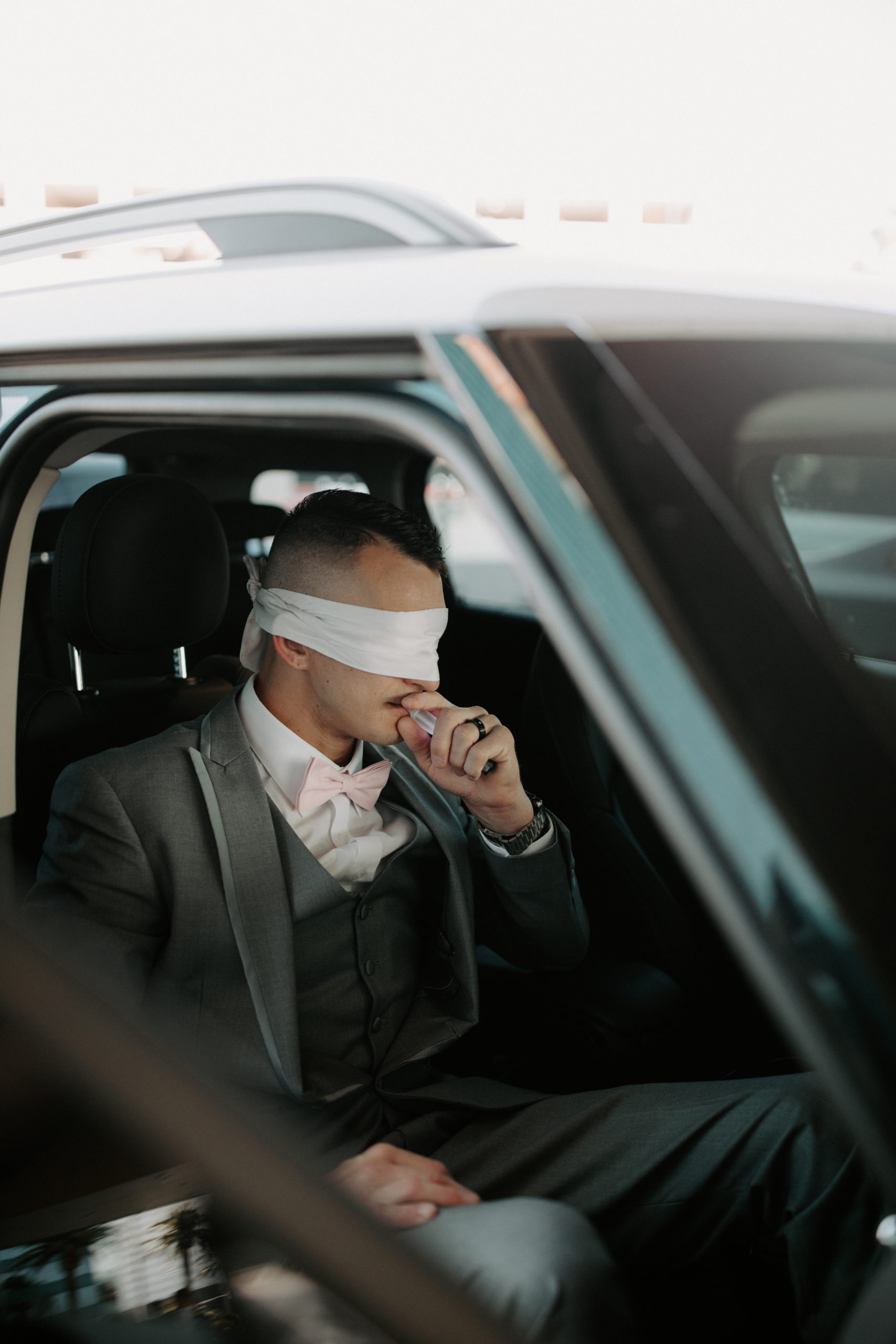 Groom in limo with blind fold awaiting first look in Las Vegas 