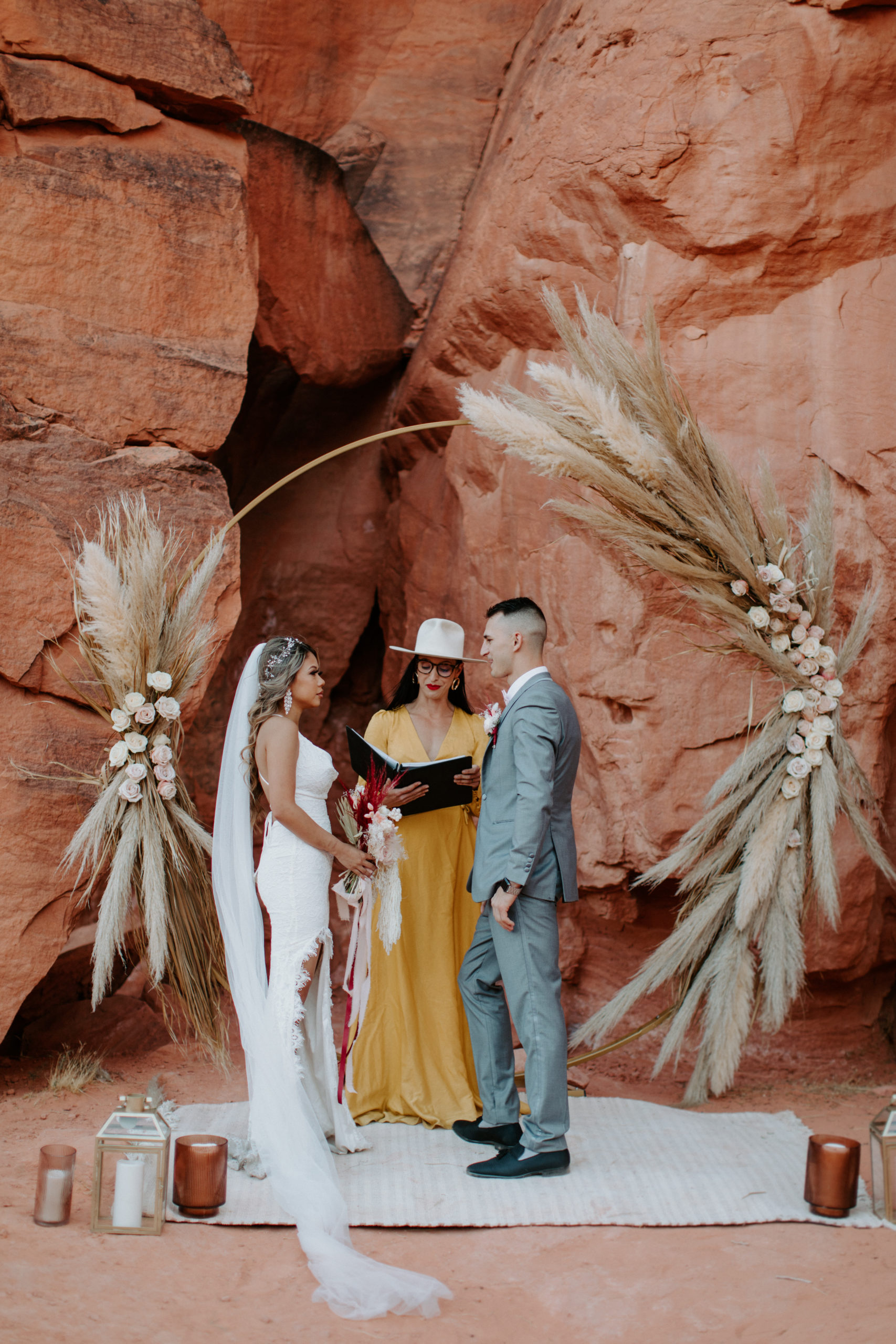 Bride and Groom under dramatic pampas and rose circle arch set-up for Boho Pampas Desert Elopement