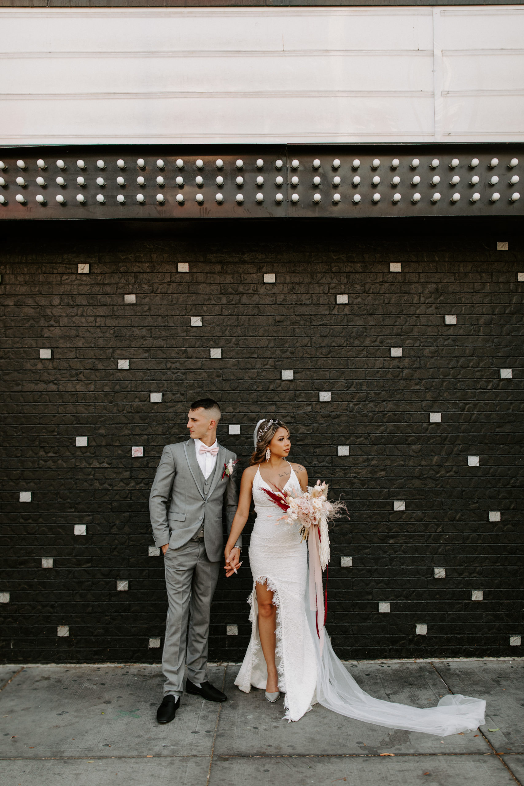 Groom in Gray Suit and Bride in Lace Bridal Dress with Slit in Downtown Las Vegas after First Look 