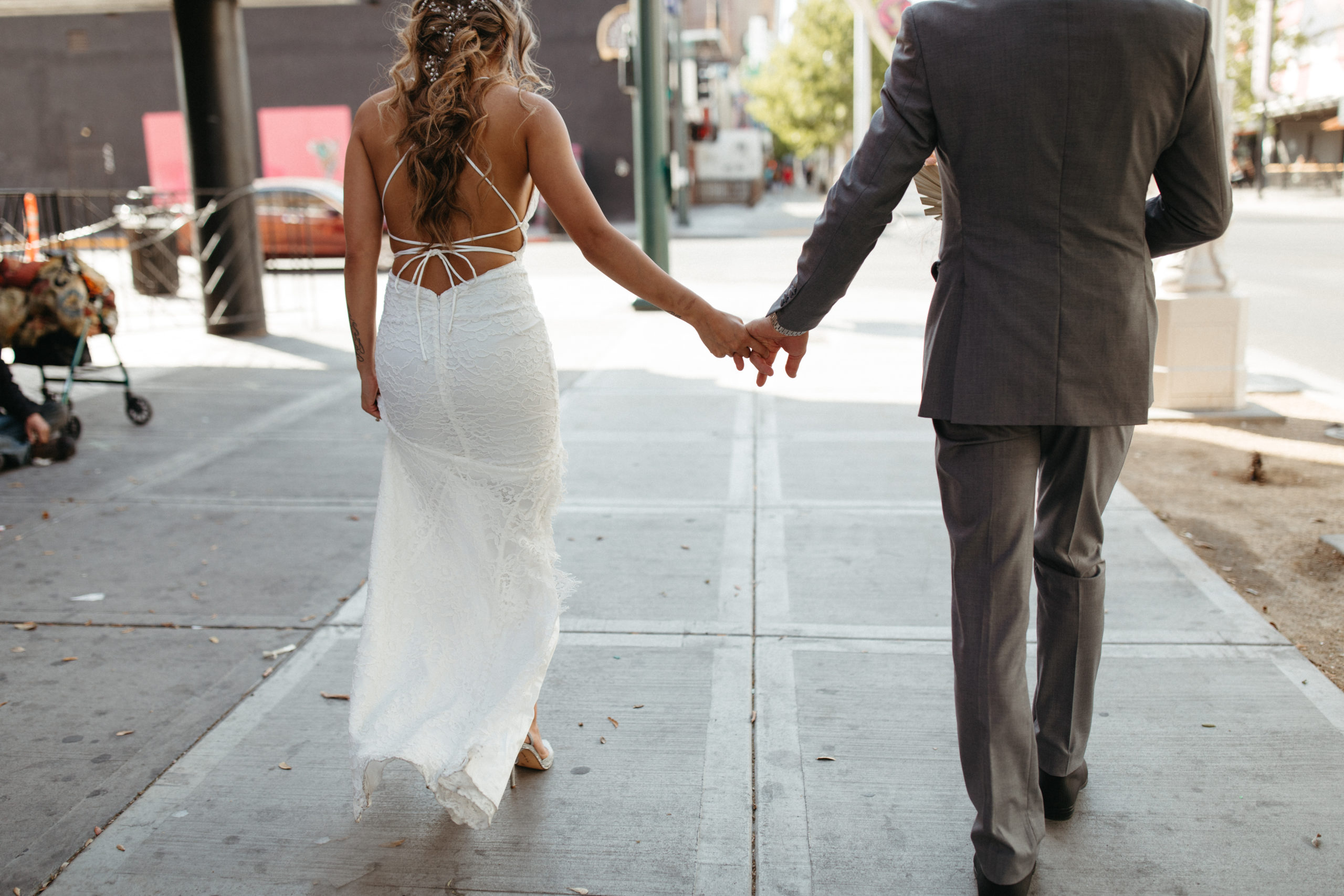 Bride in Detailed Lace Bridal Gown walking with Groom in Las Vegas Street 