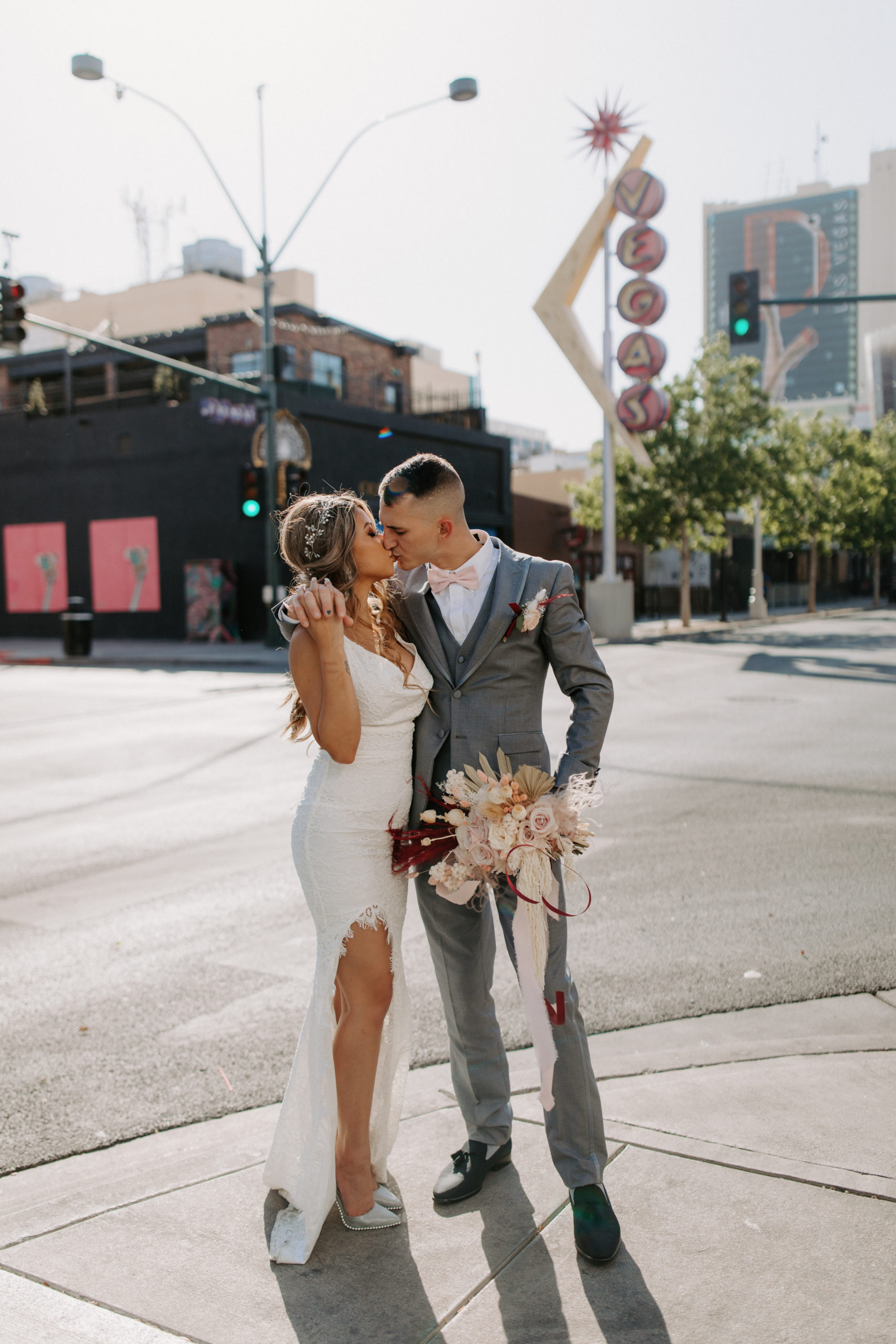 Bride and Groom kissing on street with old Vegas Sign behind them 
