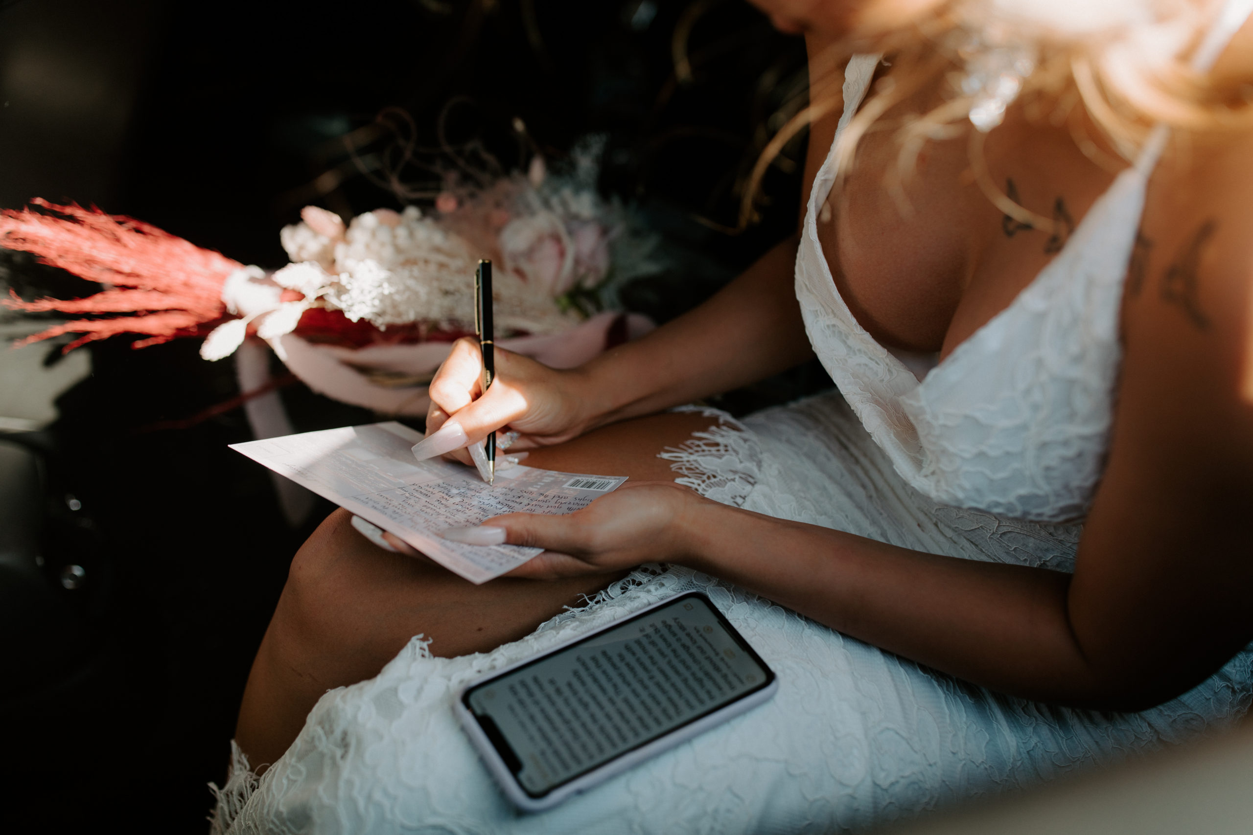 Bride copying vows down on long party bus ride to Valley of Fire ceremony location 