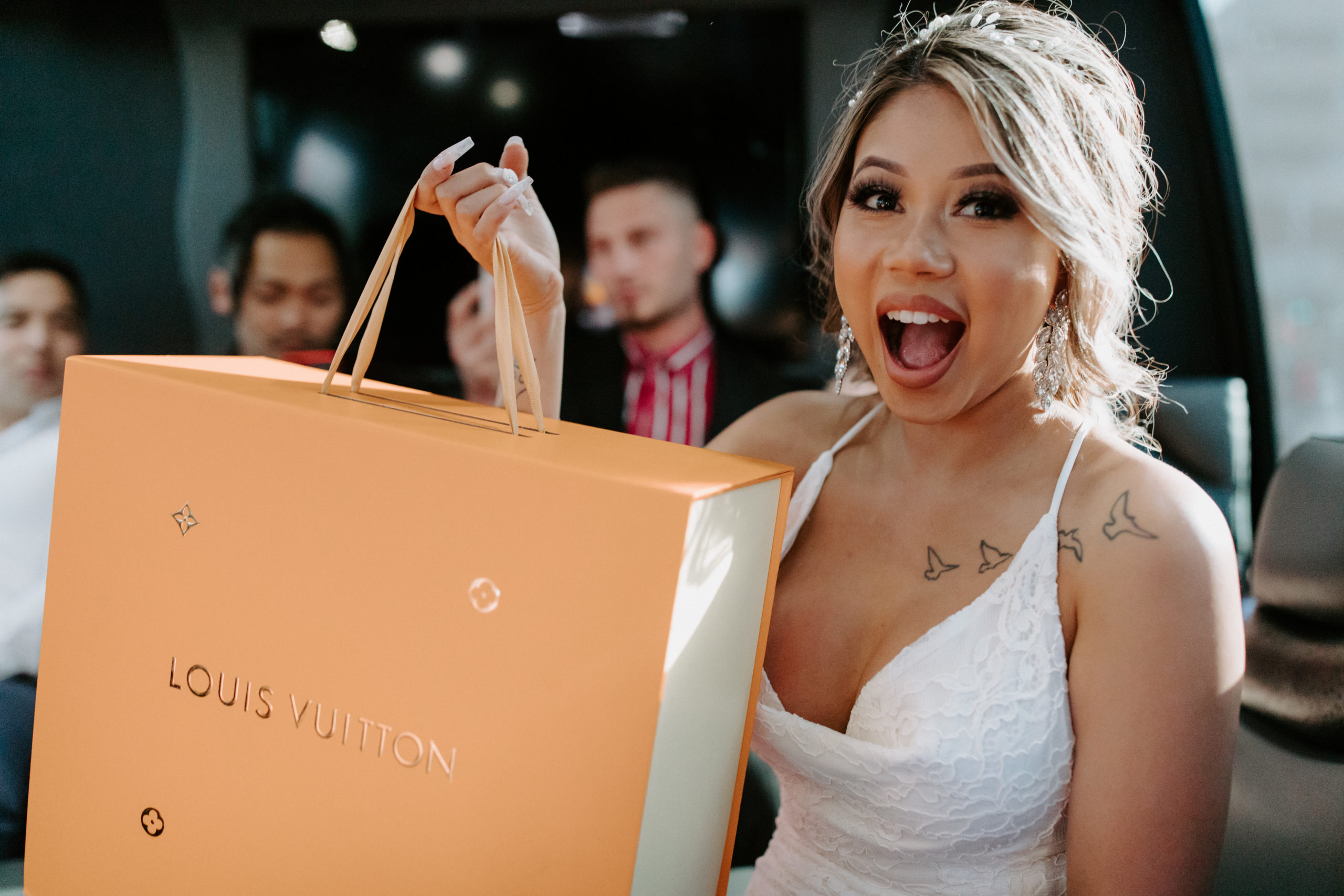 Bride opening Louis Vuitton gift on Party bus on their way to elope in the Las Vegas desert 