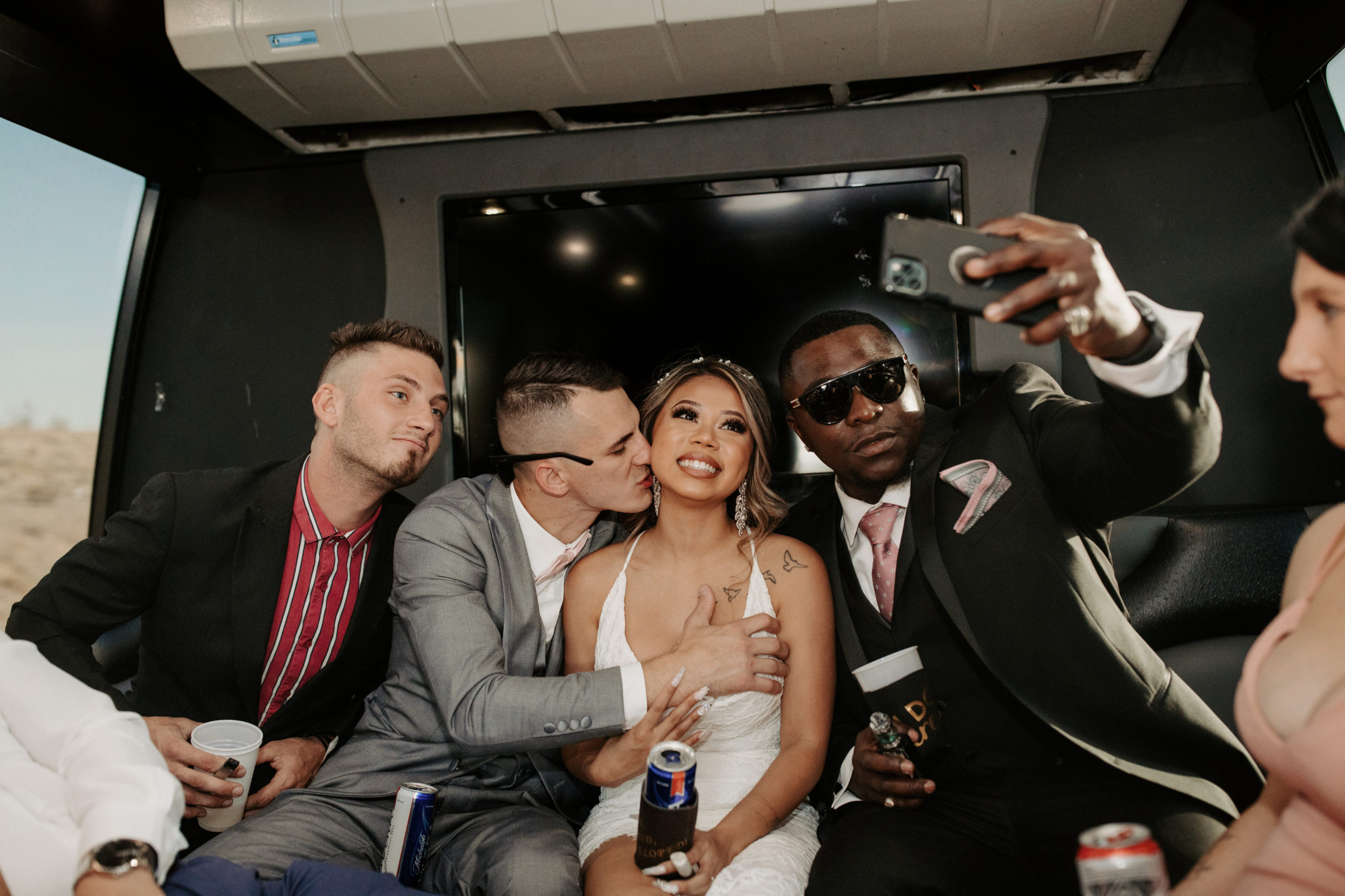Friends taking selfie with the bride & groom on party bus 