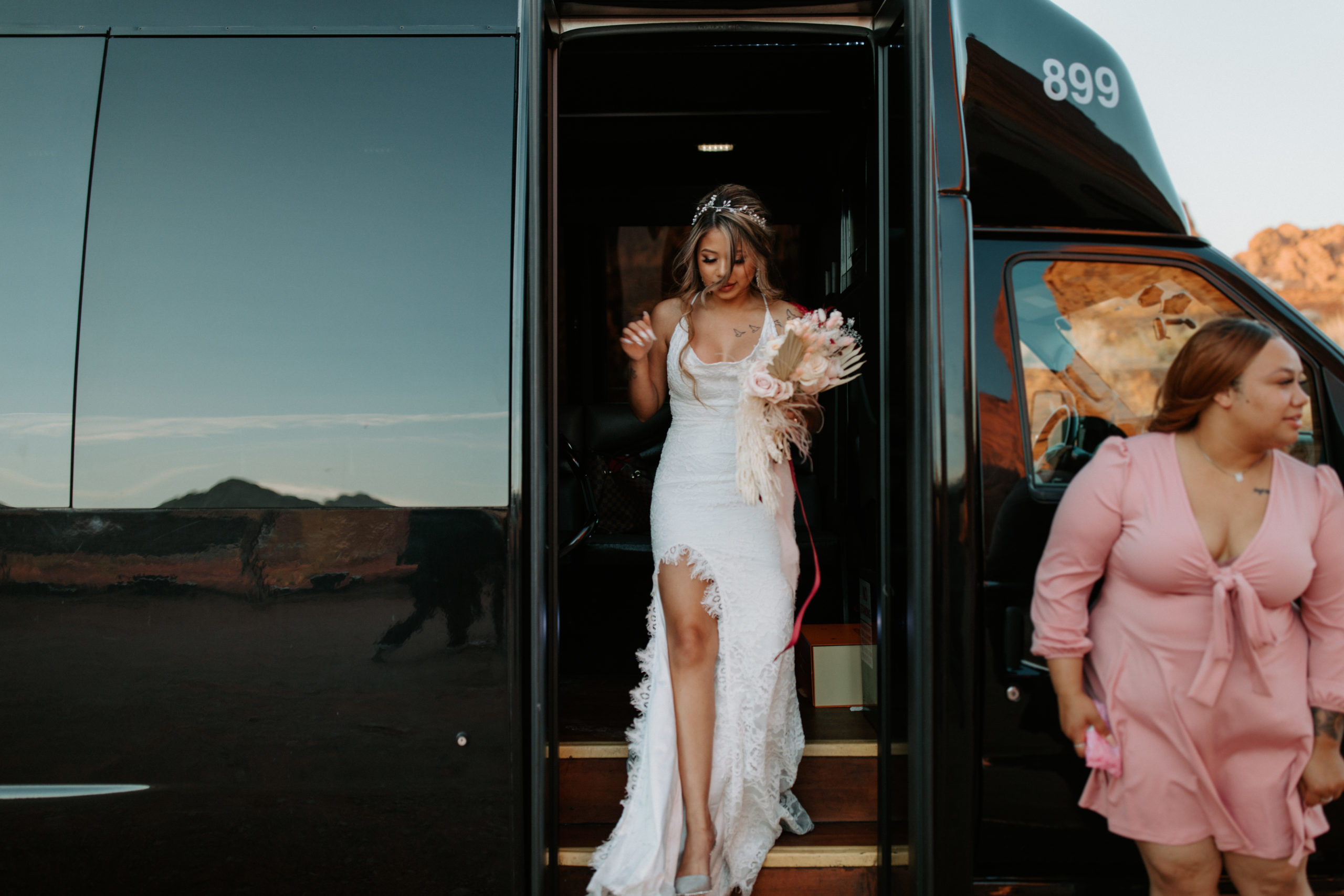 Bride stepping off party bus upon arrival in Valley of Fire for Elopement 