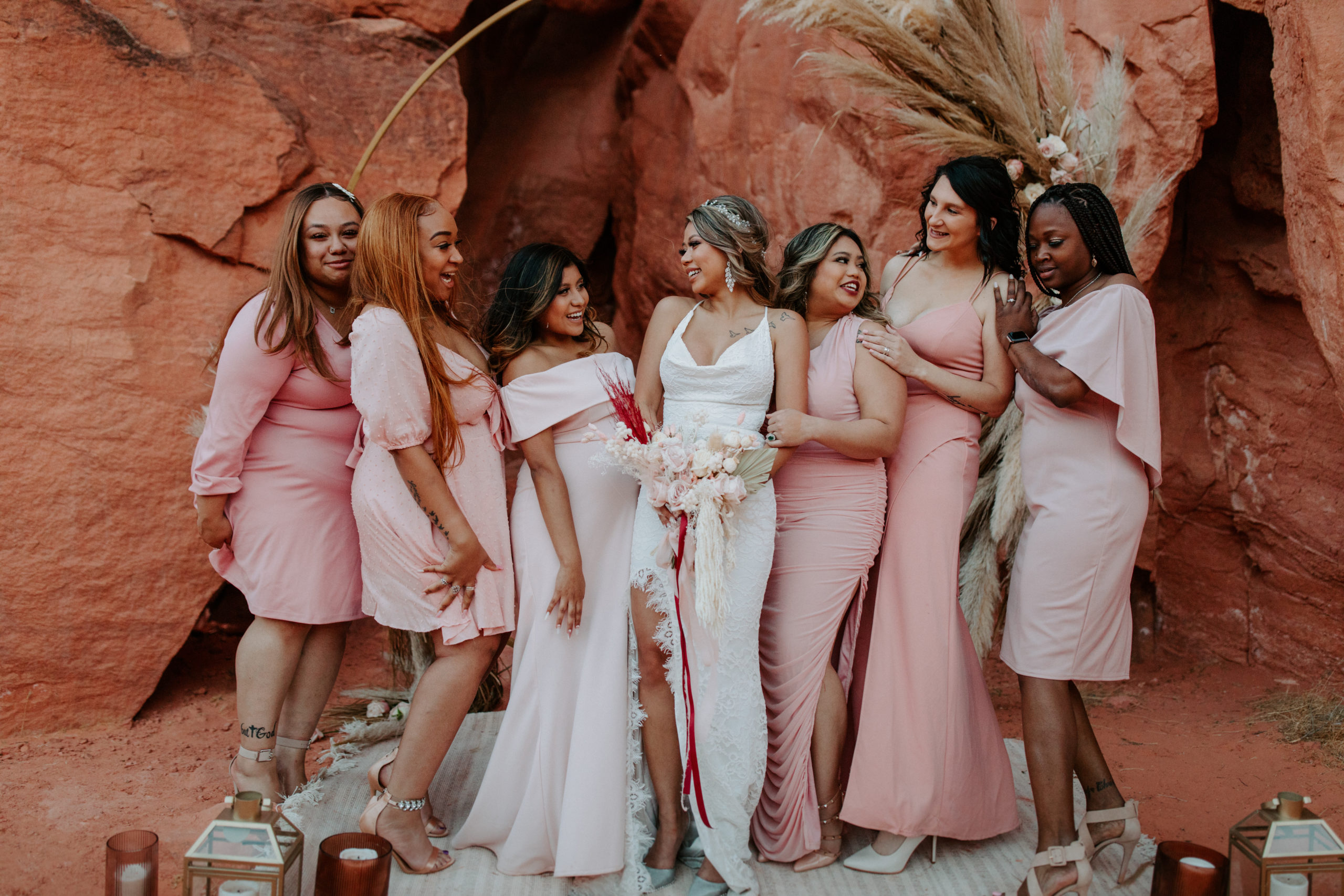 Bride celebrating with her guests dressed in pink bridesmaid party dresses during Boho Pampas Desert Elopement