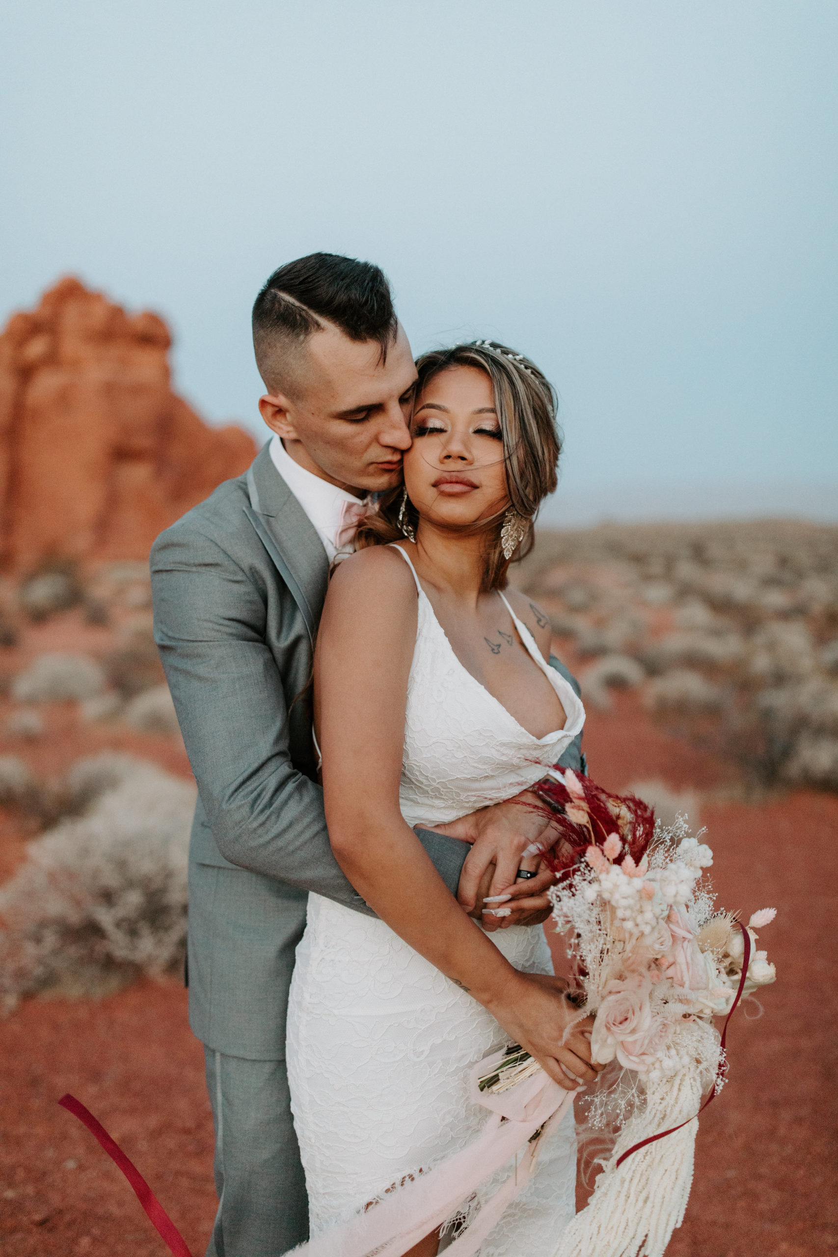 Groom holding bride in desert after intimate elopement just outside of Las Vegas 