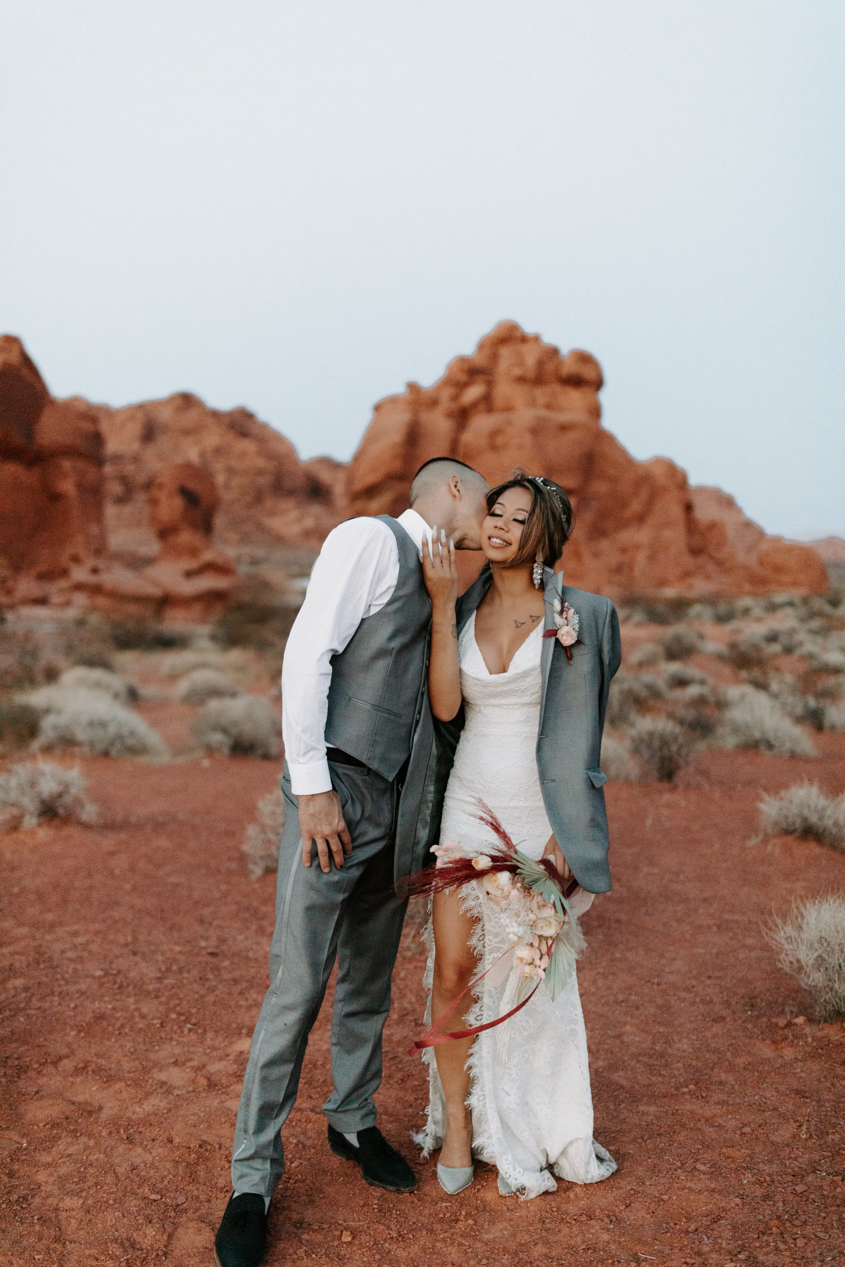 Groom kissing bride in the Valley of Fire after elopement 