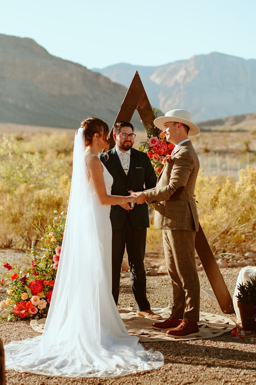 Couple getting Married in Bright & Bold Sunset Desert Wedding 