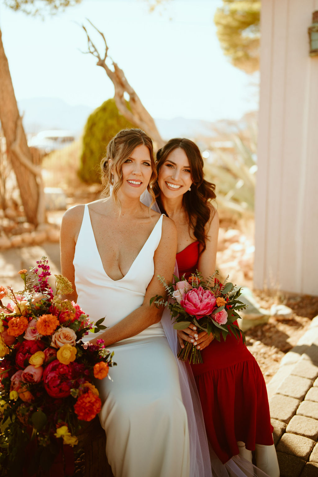 Bride with white deep V wedding gown with Bridesmaid with Bright Pink Floral Bouquet 