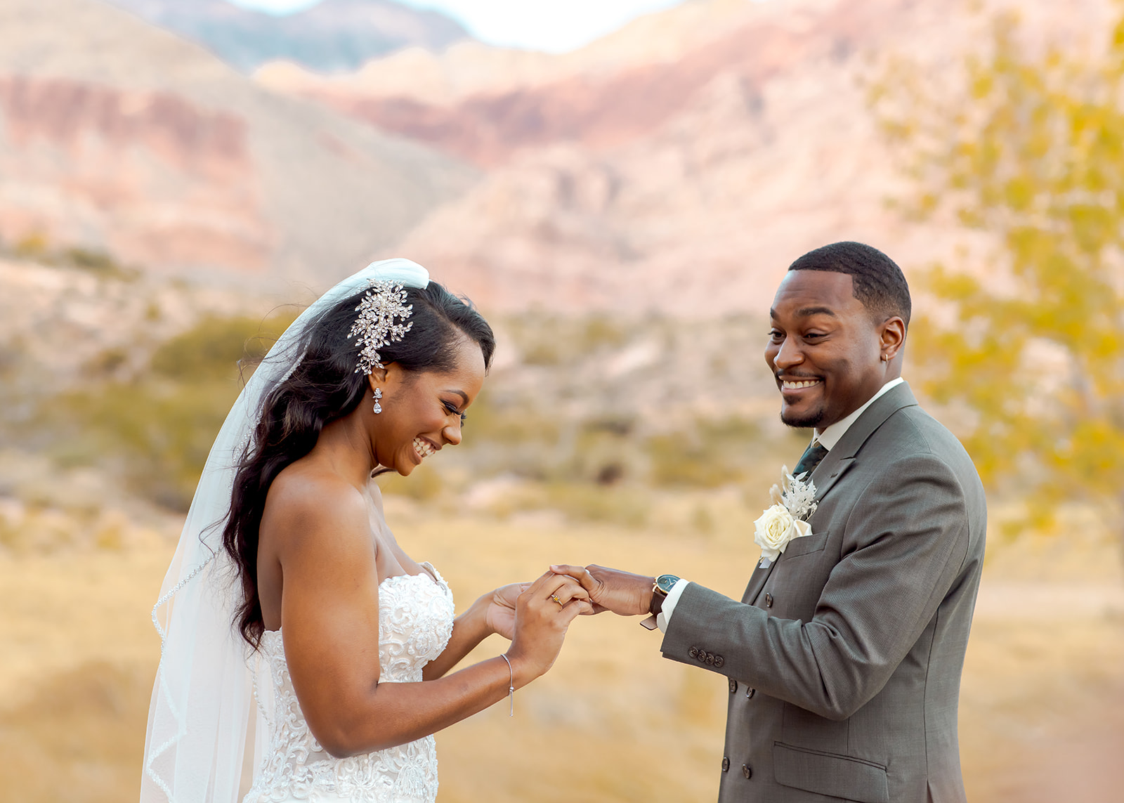 Groom happy while bride is putting the ring on his finger for Calico Basin Red Springs Autumn Elopement  