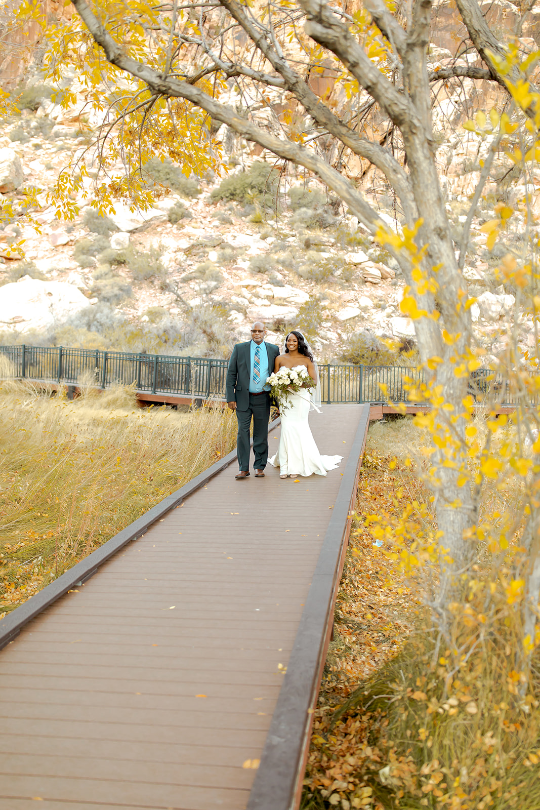 Bride walking down the aisle with yellow fall leaves and beautiful autumn colors
