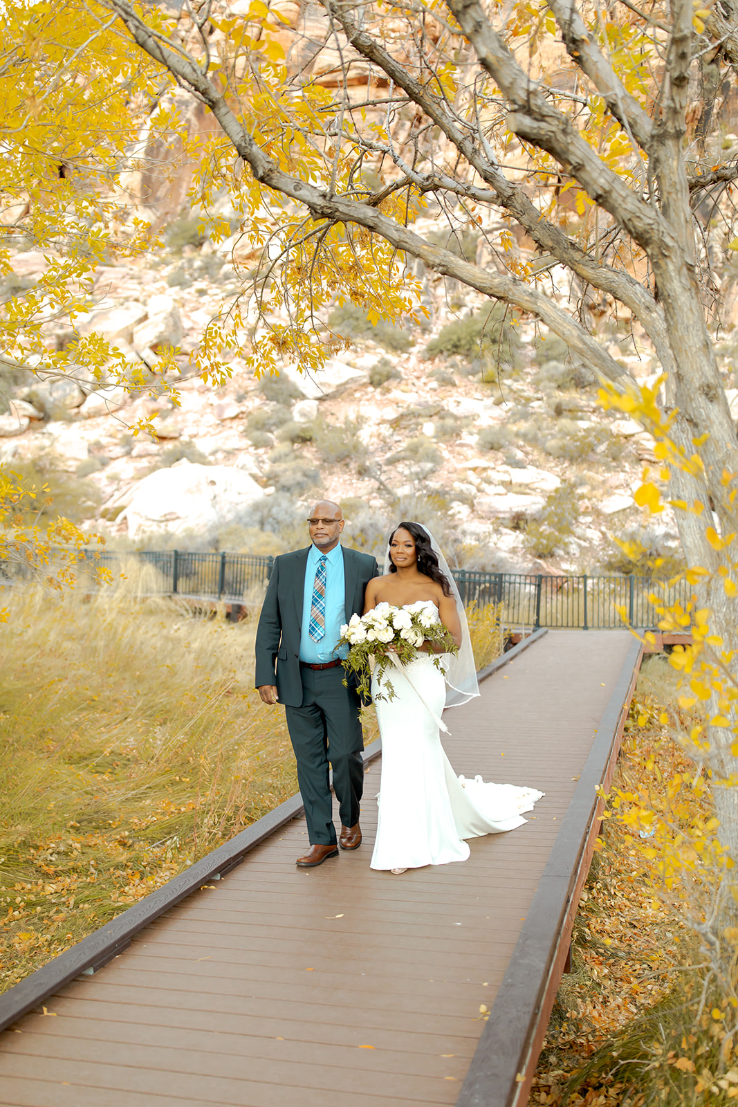 Bride walking down the aisle with yellow fall leaves for Calico Basin Red Springs Autumn Elopement  