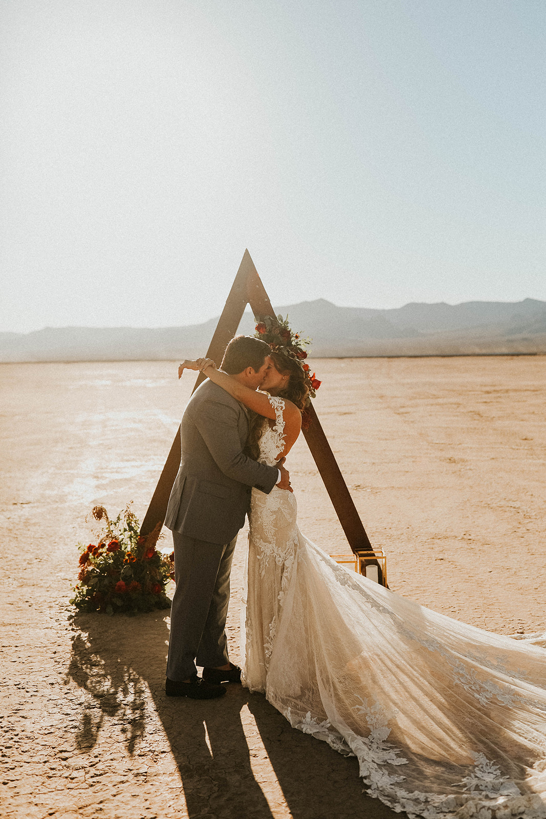 Newlyweds First Kiss under Triangle Arch for Dry Lake Bed Fall Inspired Elopement 