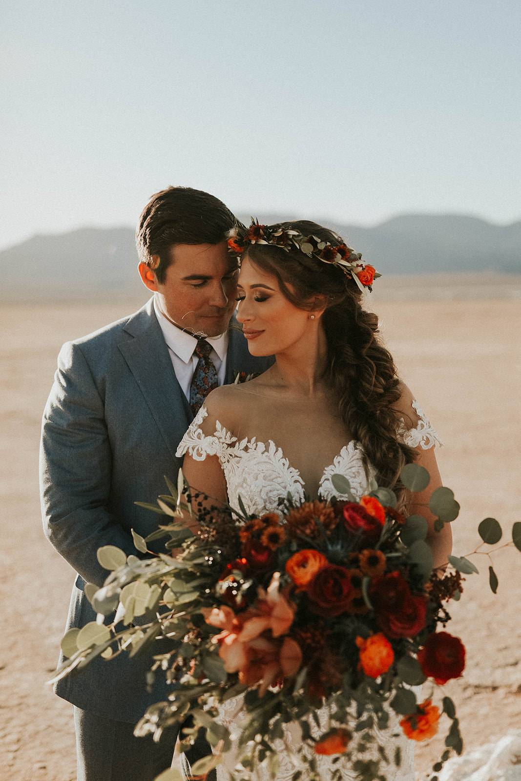 Groom in Blue Suite & Bride with Floral Crown & Bouquet Having a Moment during Dry Lake Bed Fall Inspired Elopement 