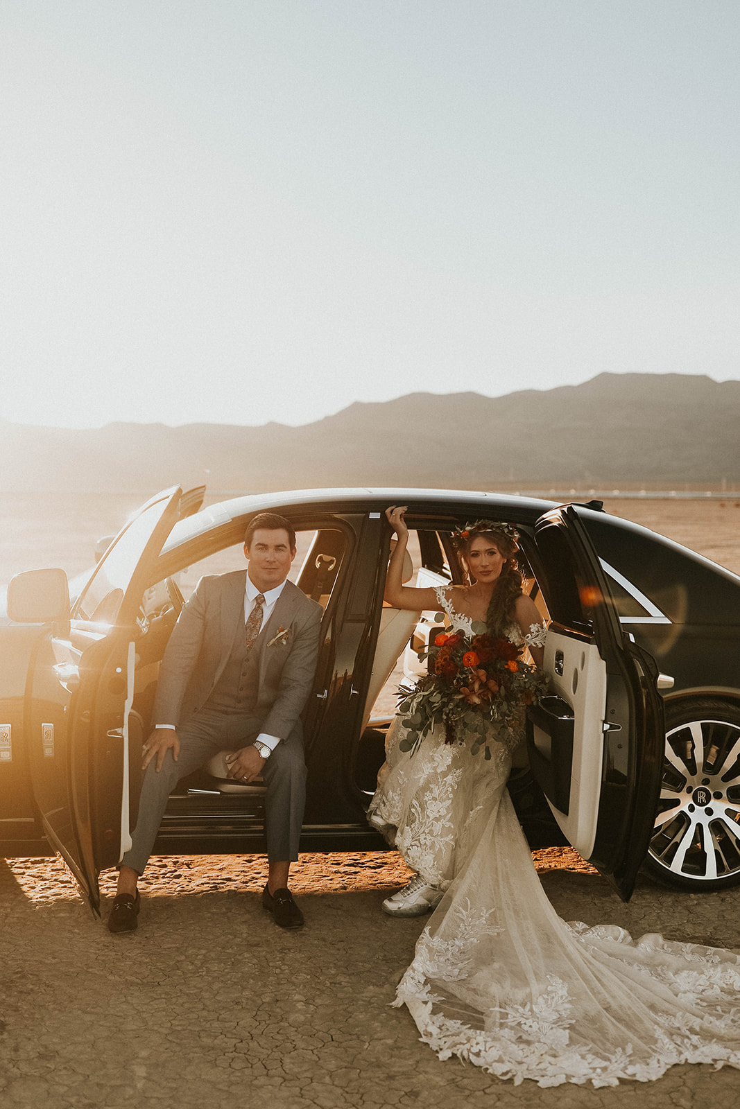 All Doors Open of Rolls Royce While Groom is in Front Seat & Bride is in the back during Dry Lake Bed Fall Inspired Elopement in Las Vegas 