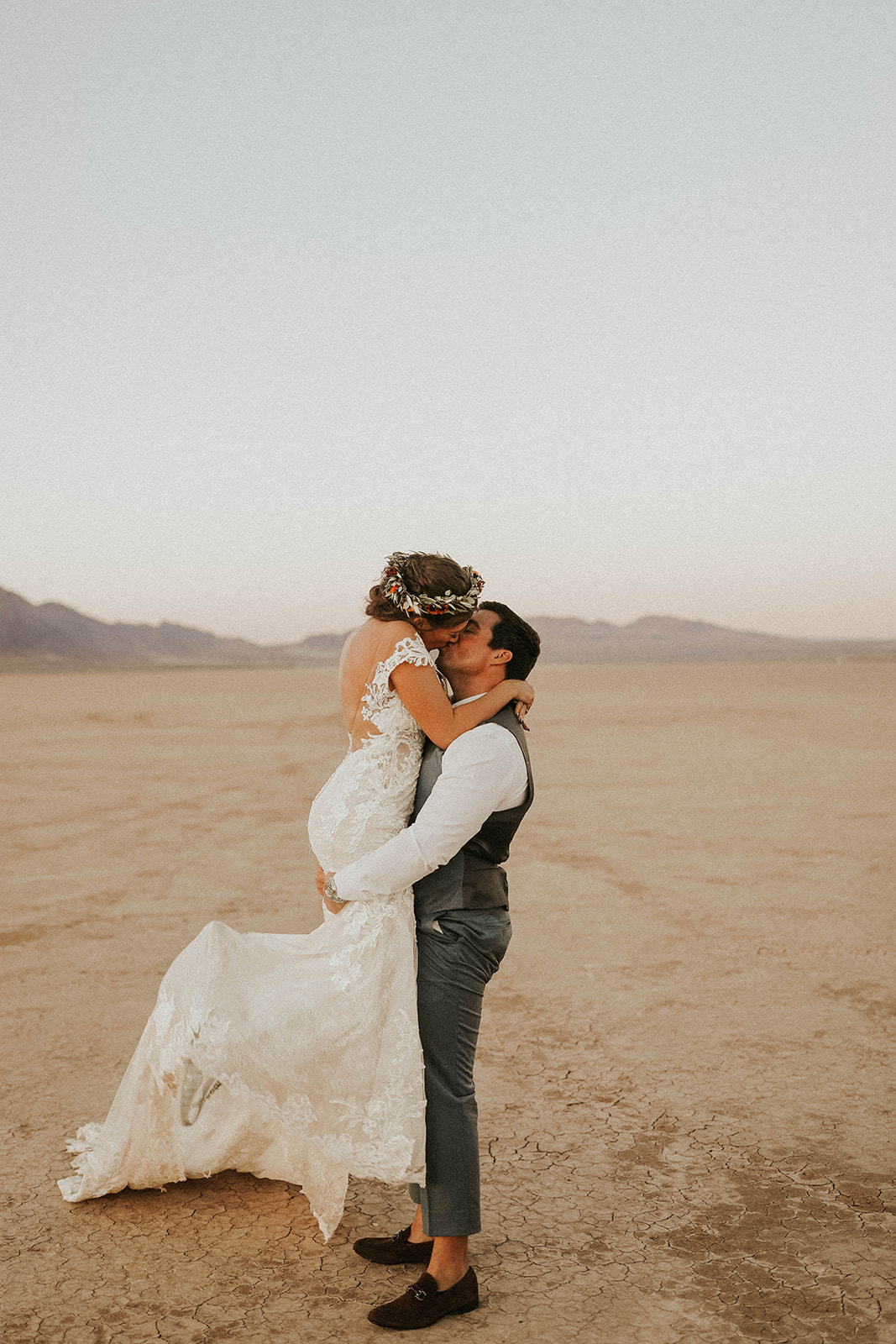 Groom Holding Bride up & Kissing on Dry Lake Bed 