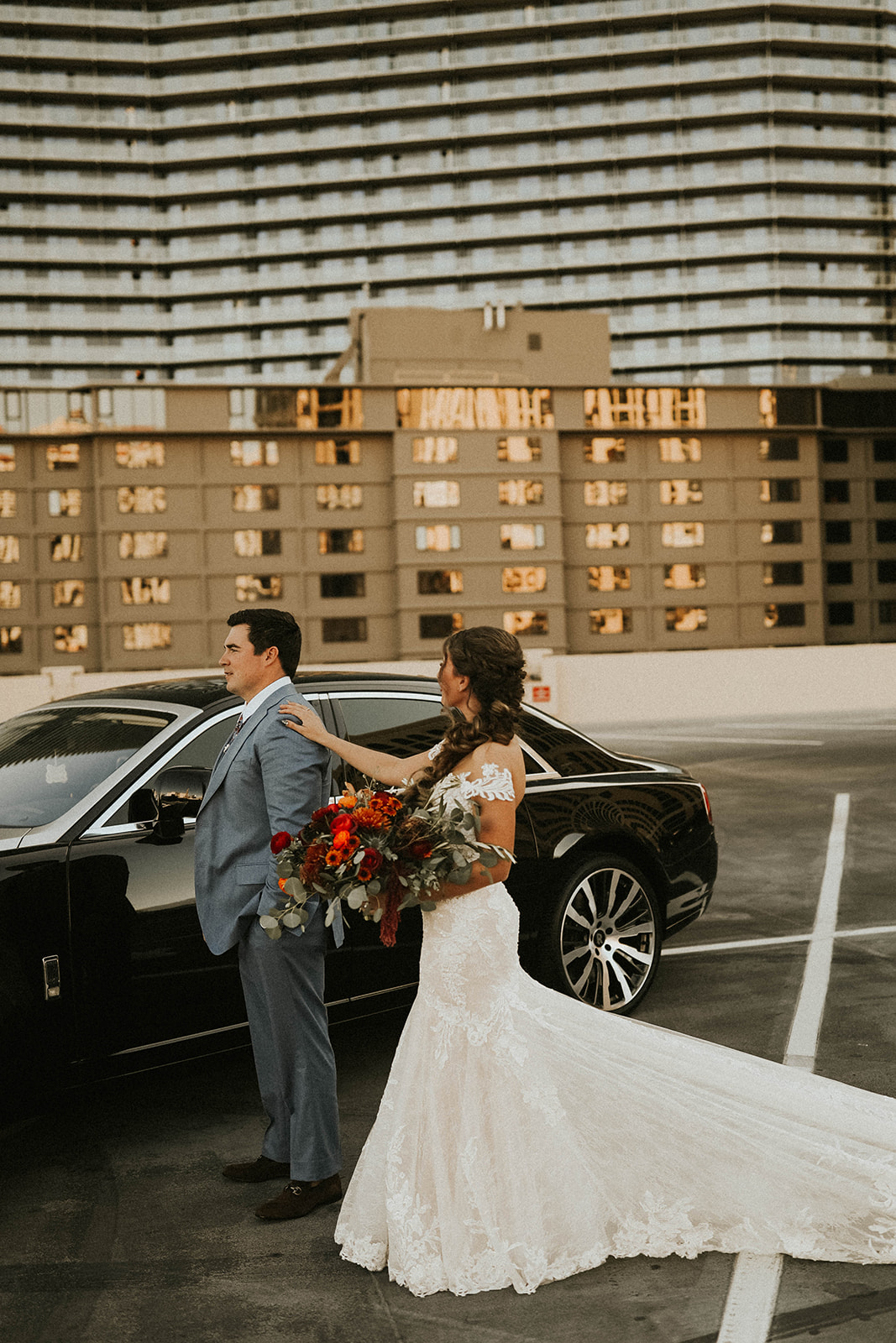 Bride touching Groom's shoulder for first look in front of Rolls Royce in Las Vegas 