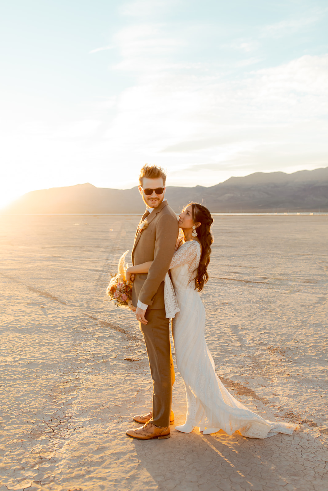Bride and Groom on Dry Lake bed During Sunset 